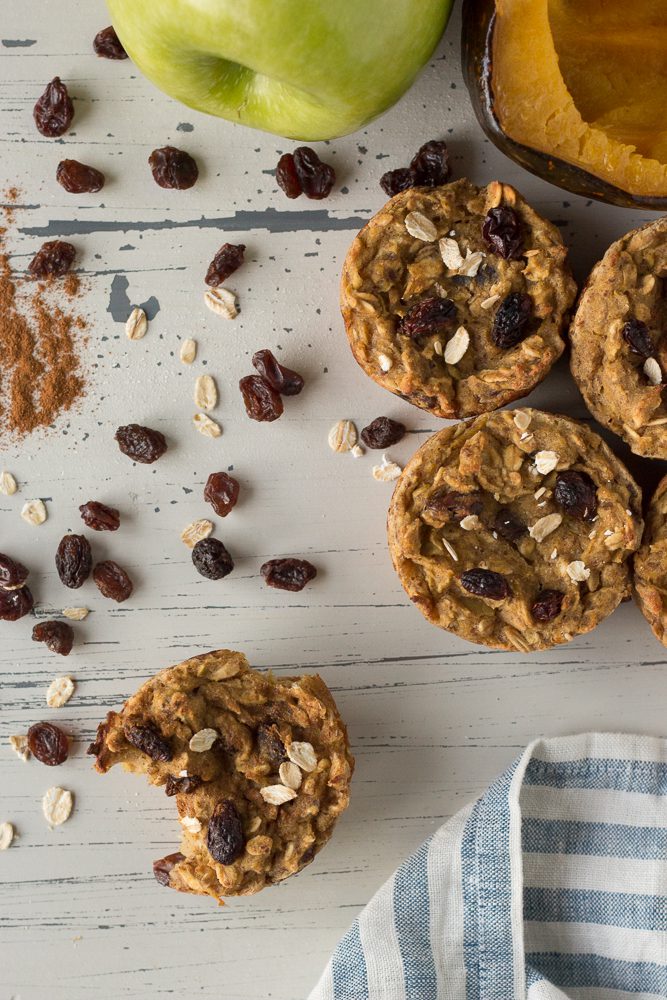 Apple Acorn Squash Muffins scattered on wooden board by Flora & Vino
