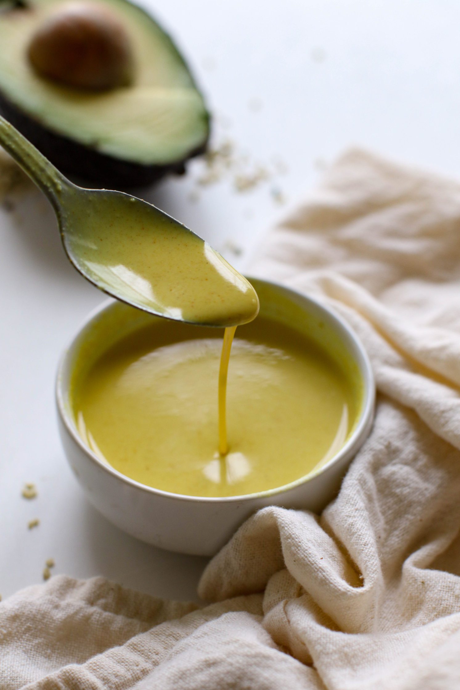 spoon with drizzling turmeric tahini dressing by Flora & Vino