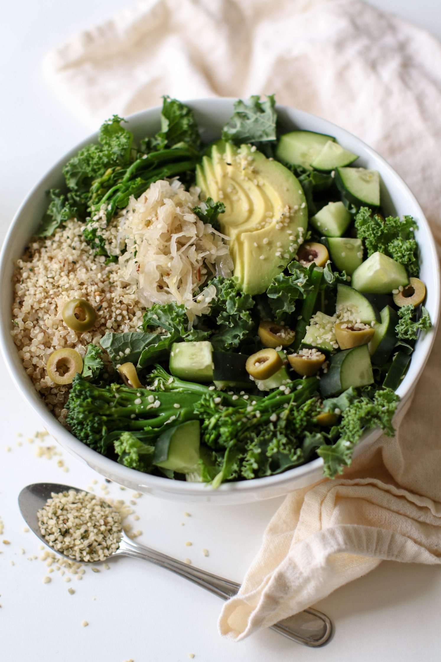 Green Macro Bowl served in a bowl without dressing with a spoon of hemp hearts by Flora & Vino