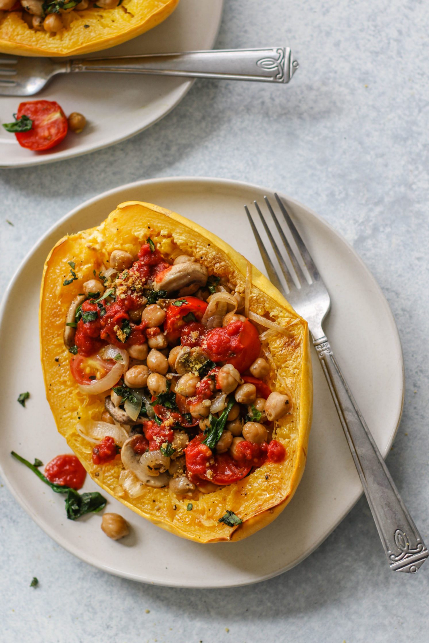 Italian Stuffed Spaghetti Squash served on plates with Crispy Chickpeas with fork by Flora & Vino