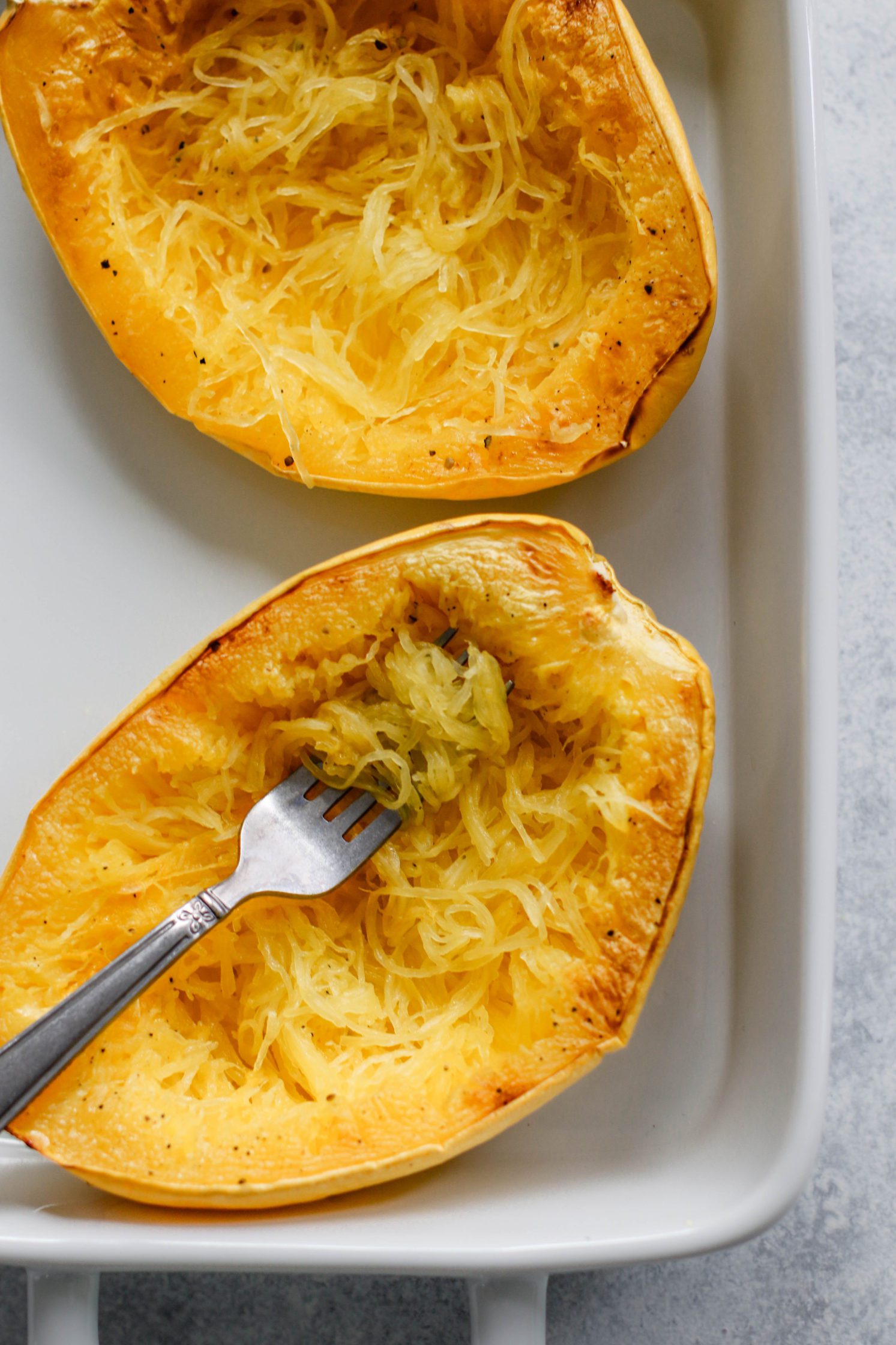 Italian Stuffed Spaghetti Squash in a casserole dish with a fork by Flora & Vino