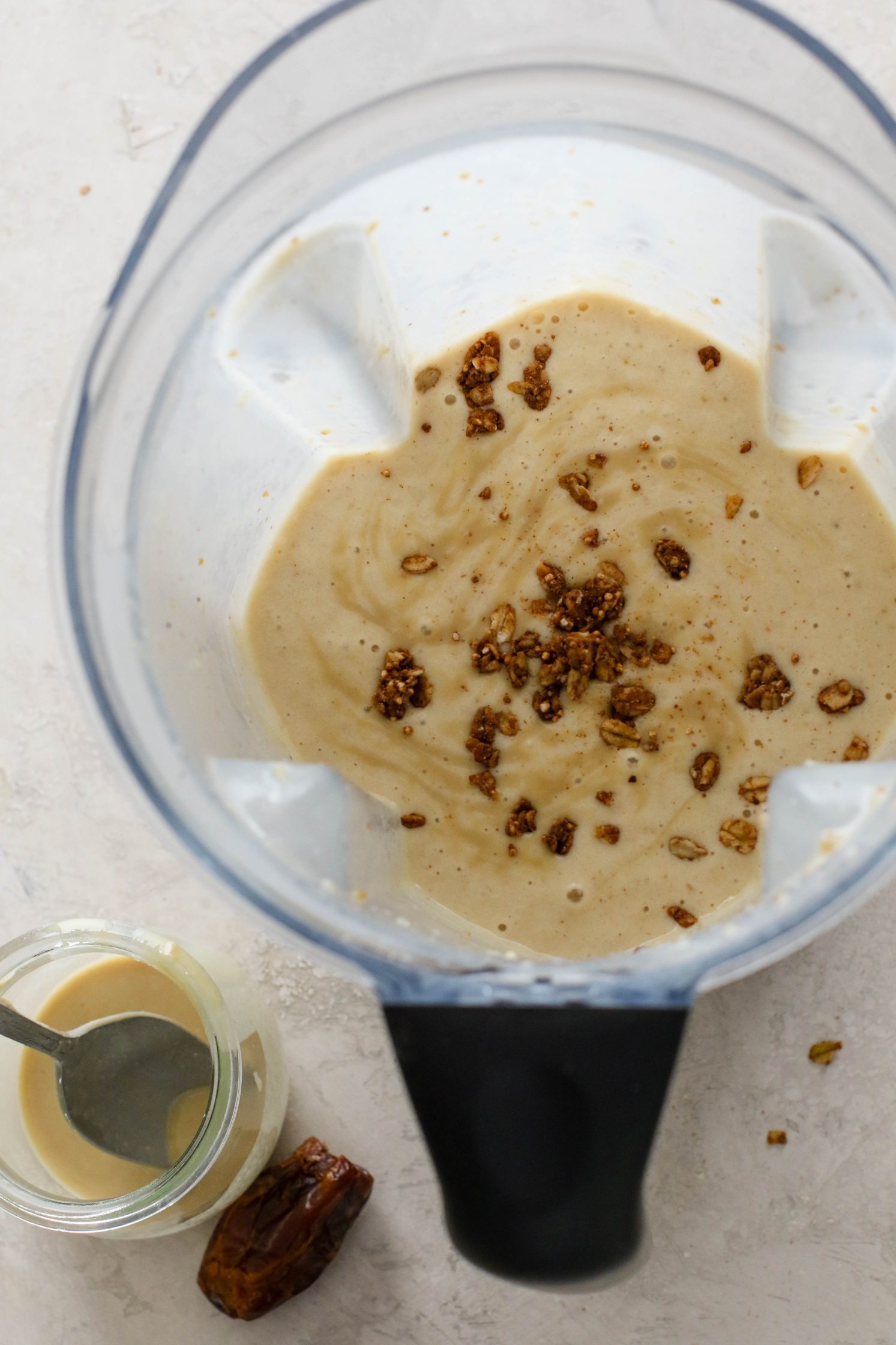 Tahini Date Shake blended in blender with granola on top by Flora & Vino
