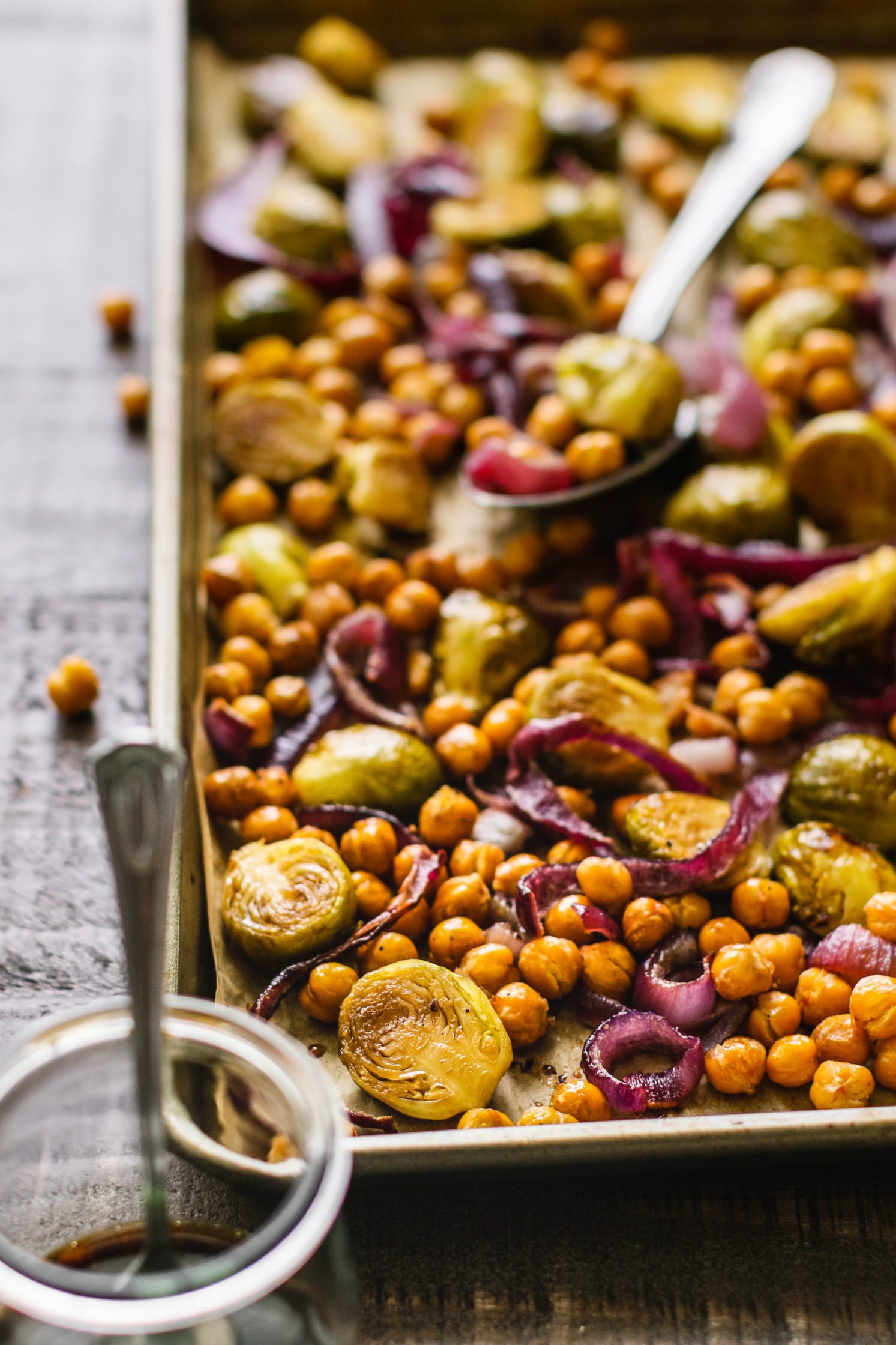 Maple Balsamic Brussels Sprouts & Chickpeas on parchment lined baking sheet by Flora & vino