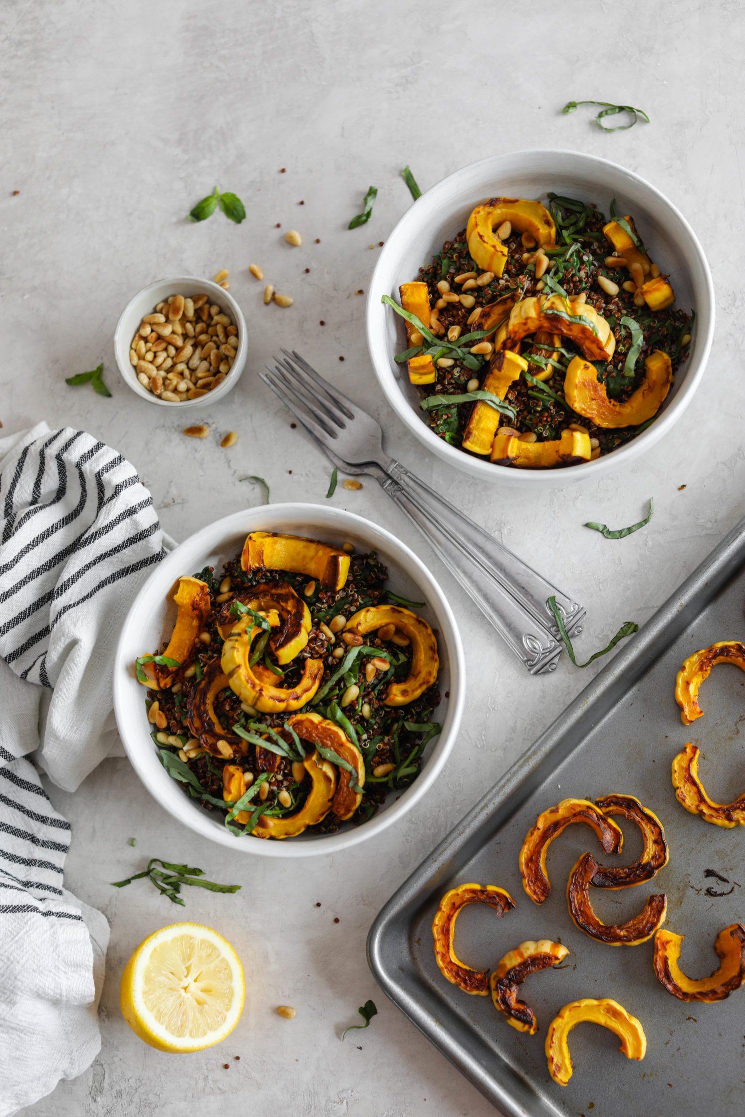 Delicata Squash Quinoa Power Bowls served with roasted delicata squash on baking sheet, pine nuts, and lemon by Flora & Vino