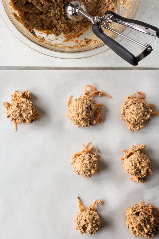 Quinoa Carrot Cake Breakfast Cookies scooped into balls on parchment lined baking sheet