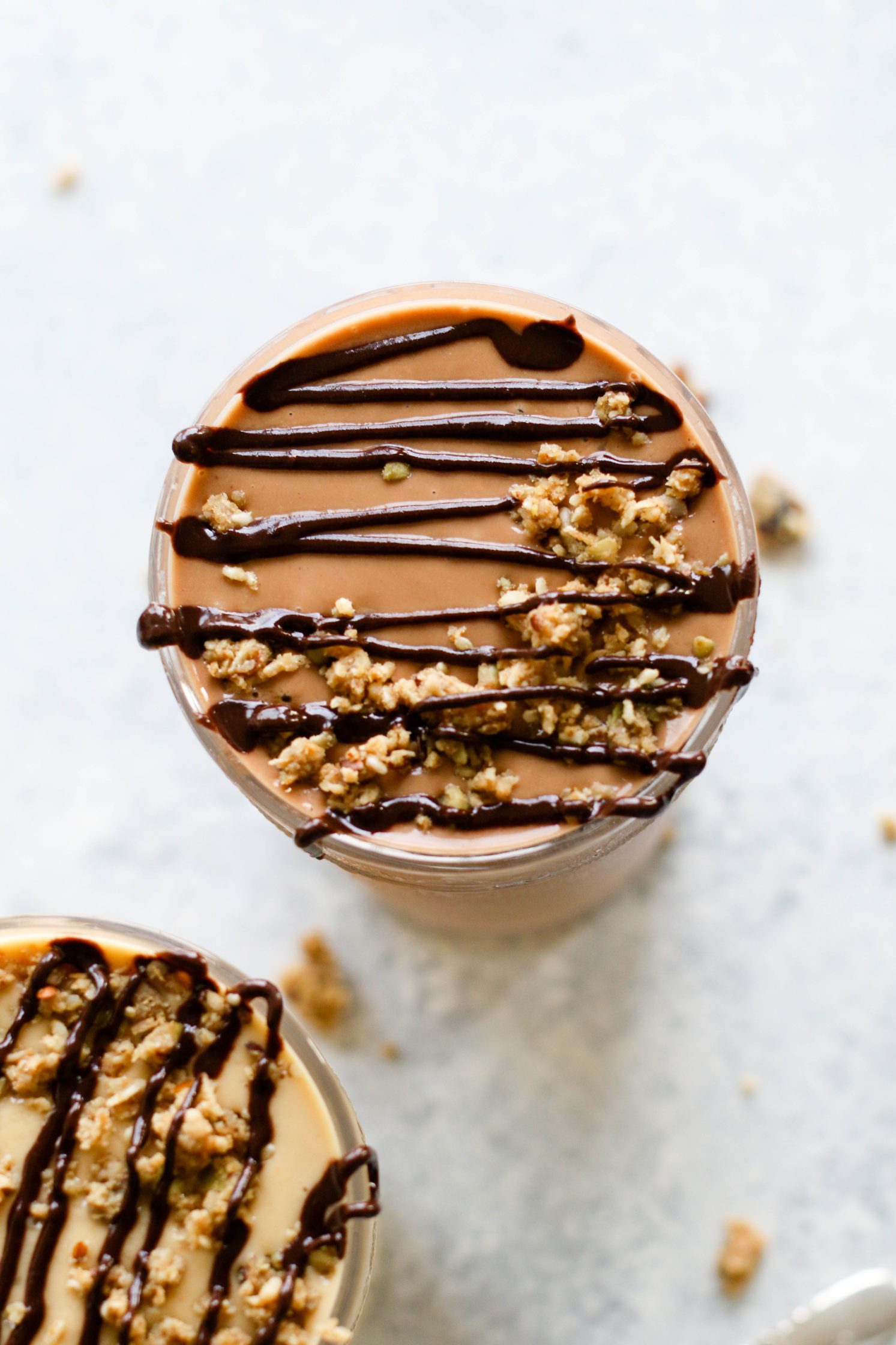 Fruit-Free "Fake Out" Shakes served in tall glasses topped with chocolate tahini and granola crumble by Flora & Vino