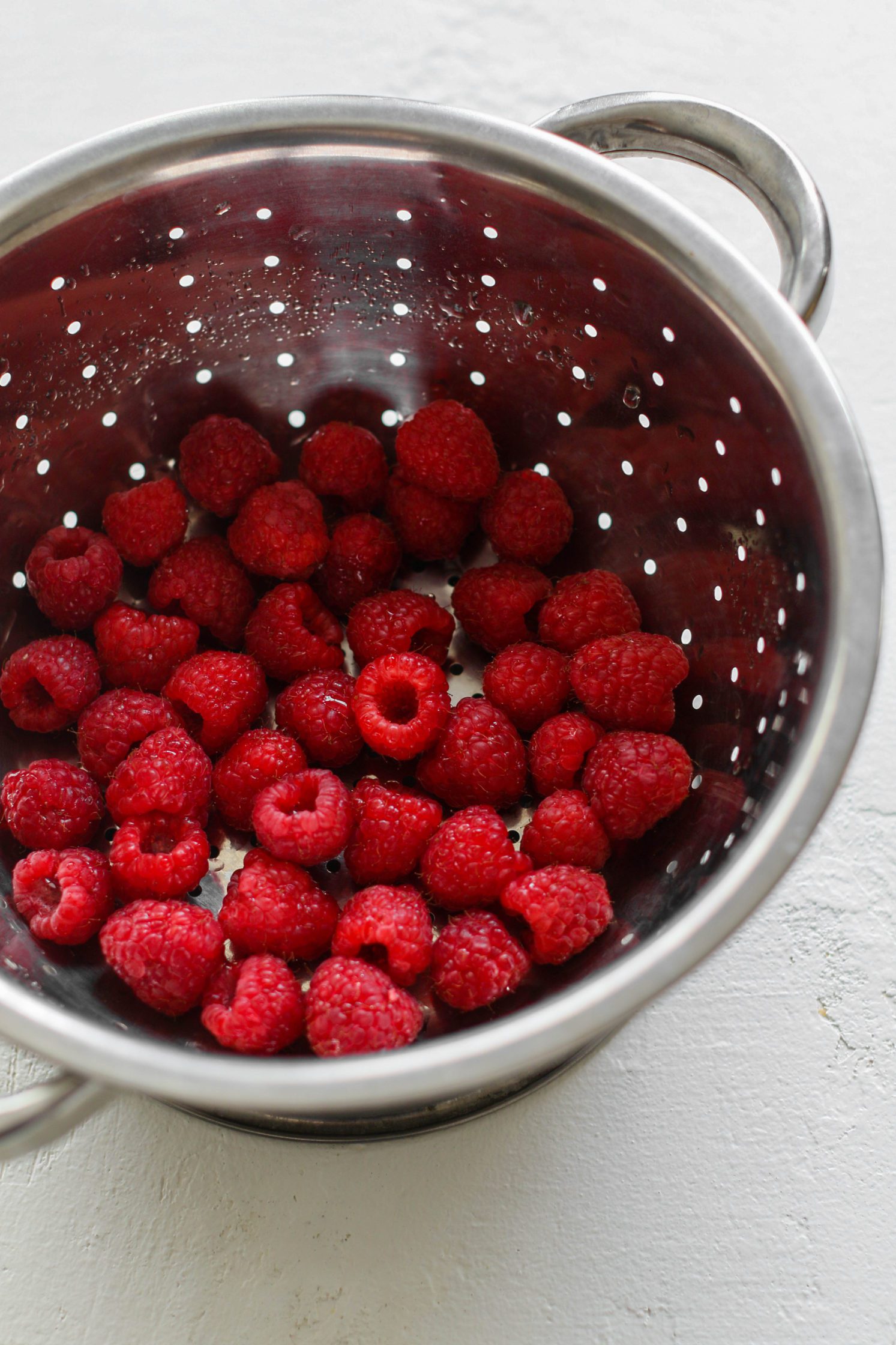 raspberries in colander by Flora & Vino
