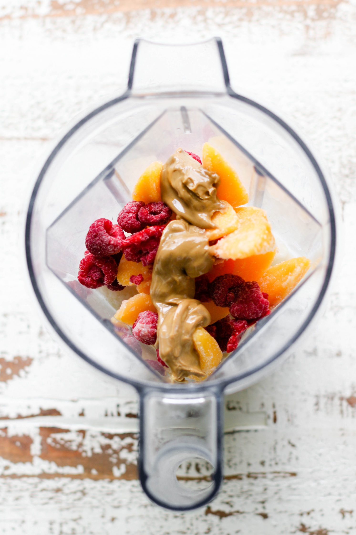 ingredeints for Peach Raspberry Sunbutter Smoothie Bowl in Vitamix blender