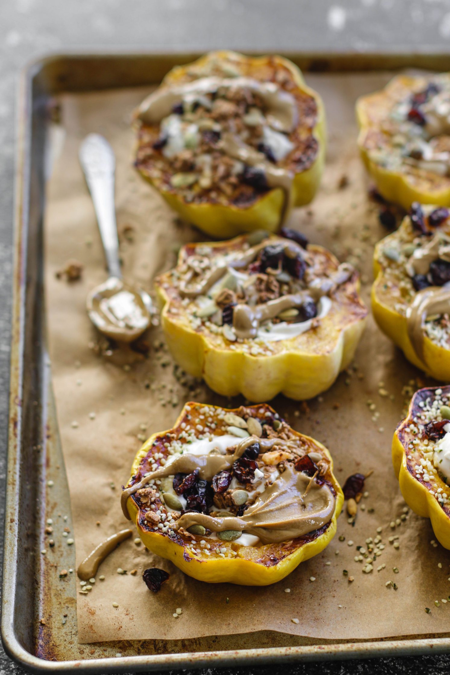 Breakfast Stuffed Squash on parchment lined baking sheet by Flora & Vino