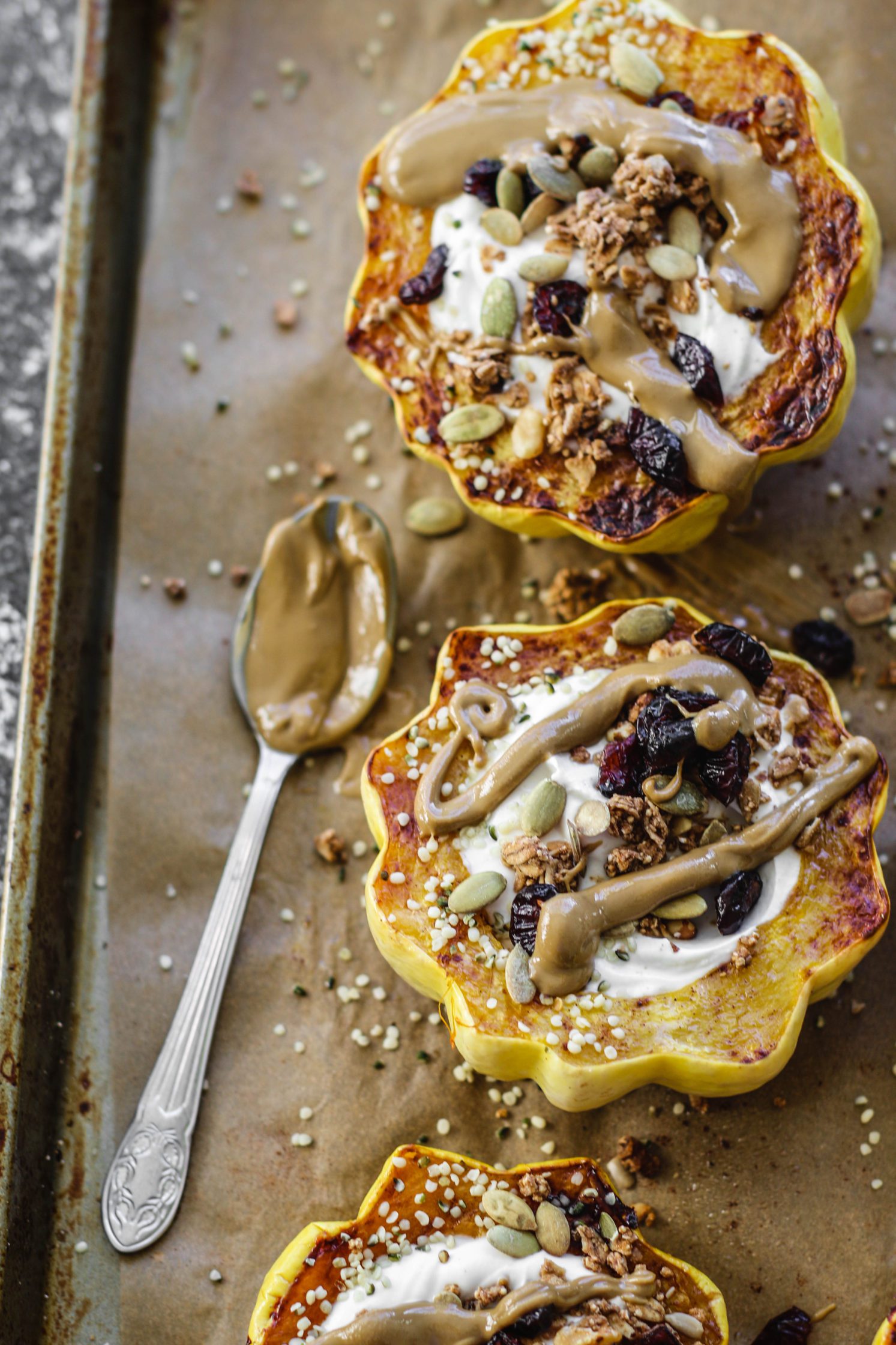 Breakfast Stuffed Squash on parchment lined baking sheet by Flora & Vino