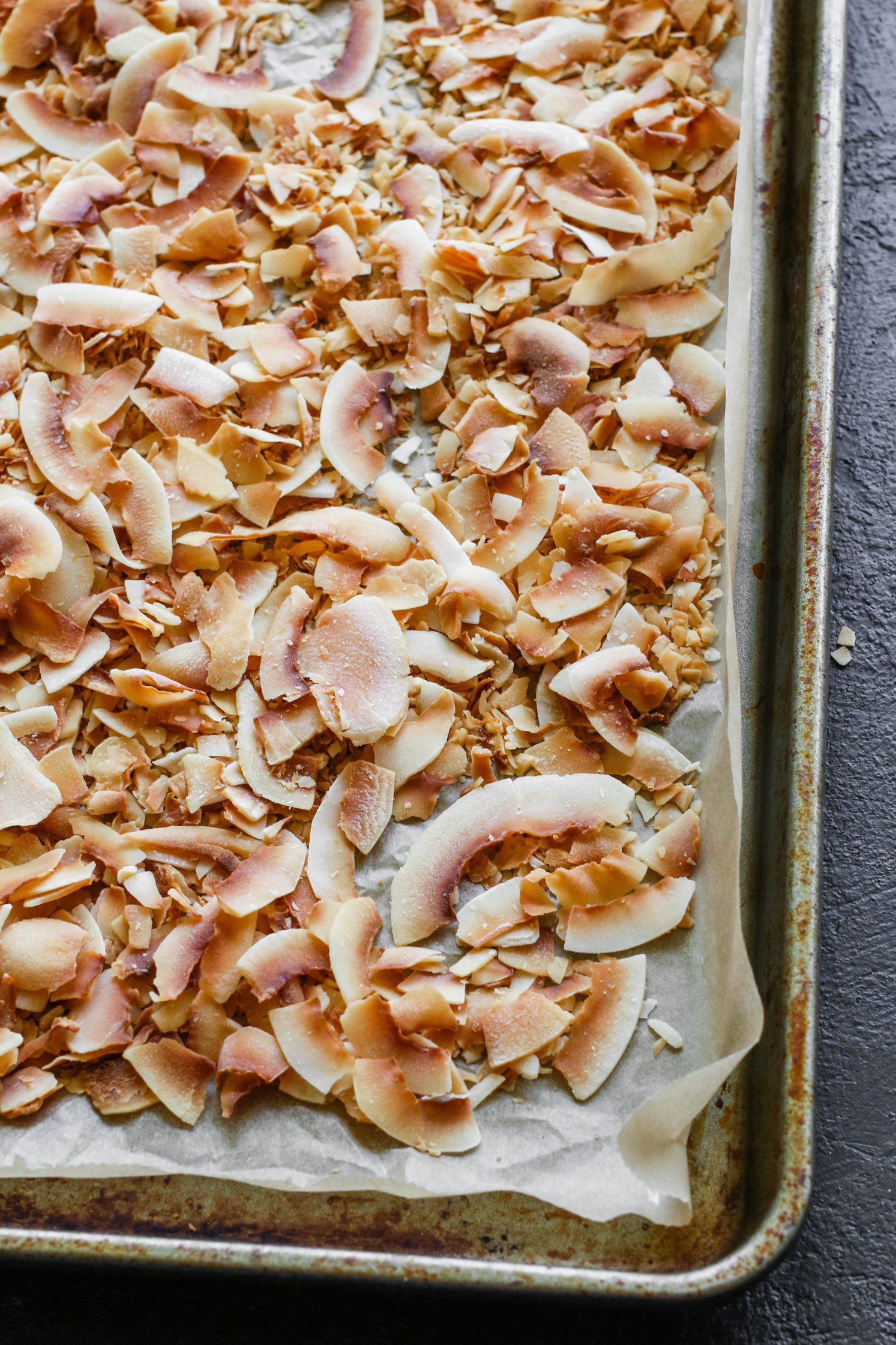 Vegan Toasted Coconut on parchment lined baking dish 