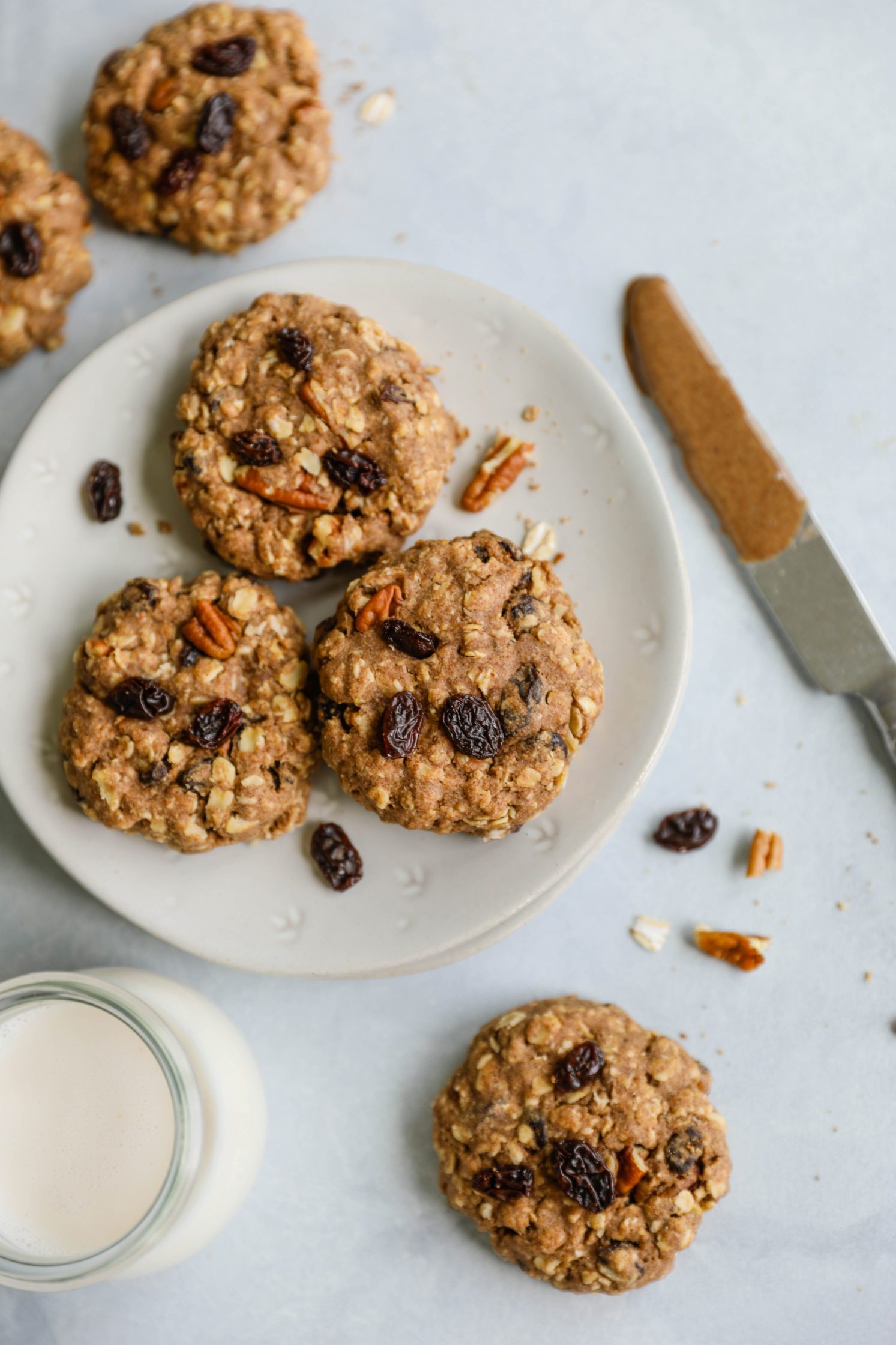 Oatmeal Raisin Pecan Cookies served on a plate with almond milk by Flora & Vino