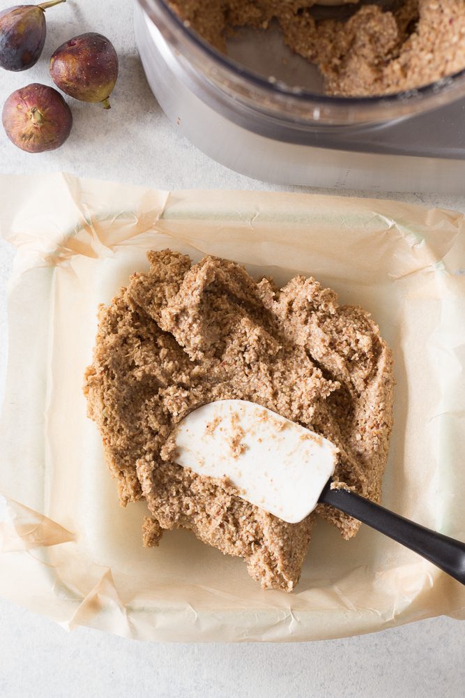 fig newton batter spread in parchment lined baking dish with spatula by Flora & Vino