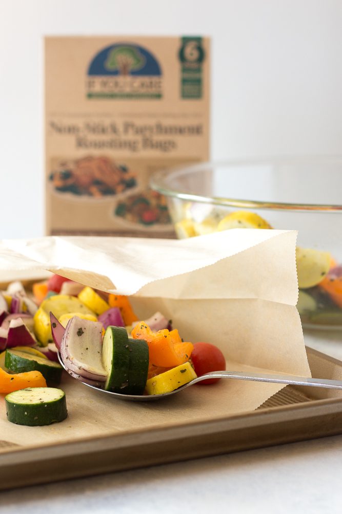 spooning vegetables on parchment lined baking sheet