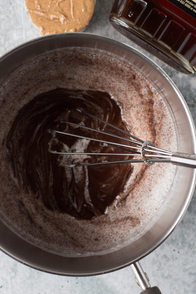whisking milk in with melted chocolate in pot