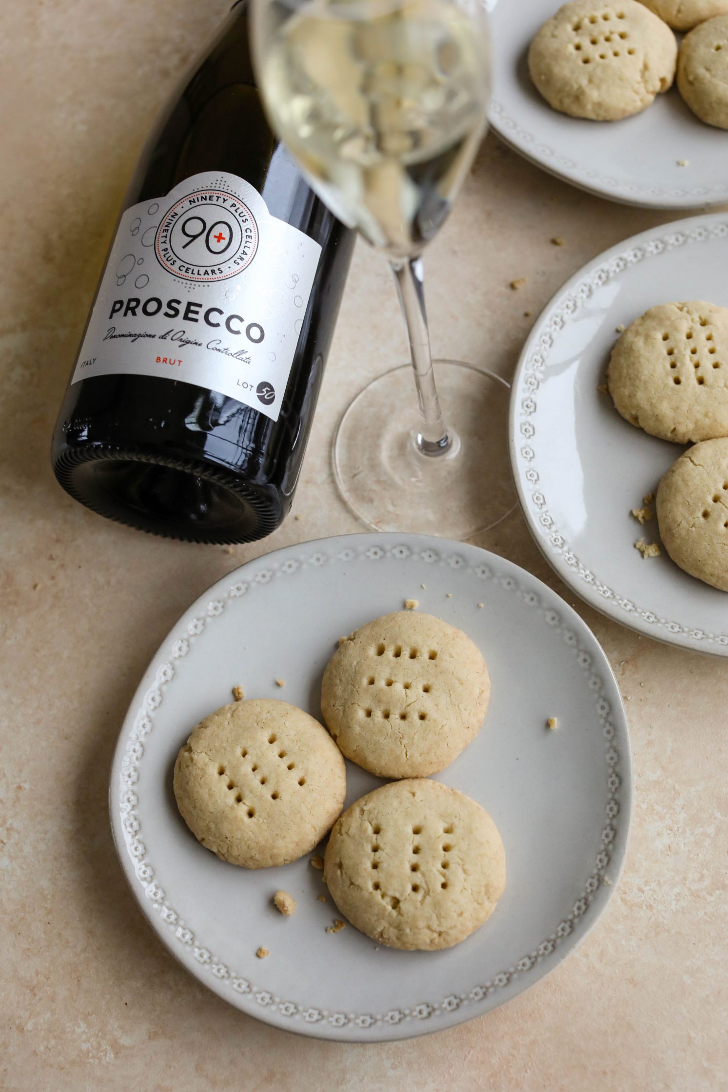 Vegan Shortbread Cookies served on plates with a glass of Prosecco by Flora & Vino