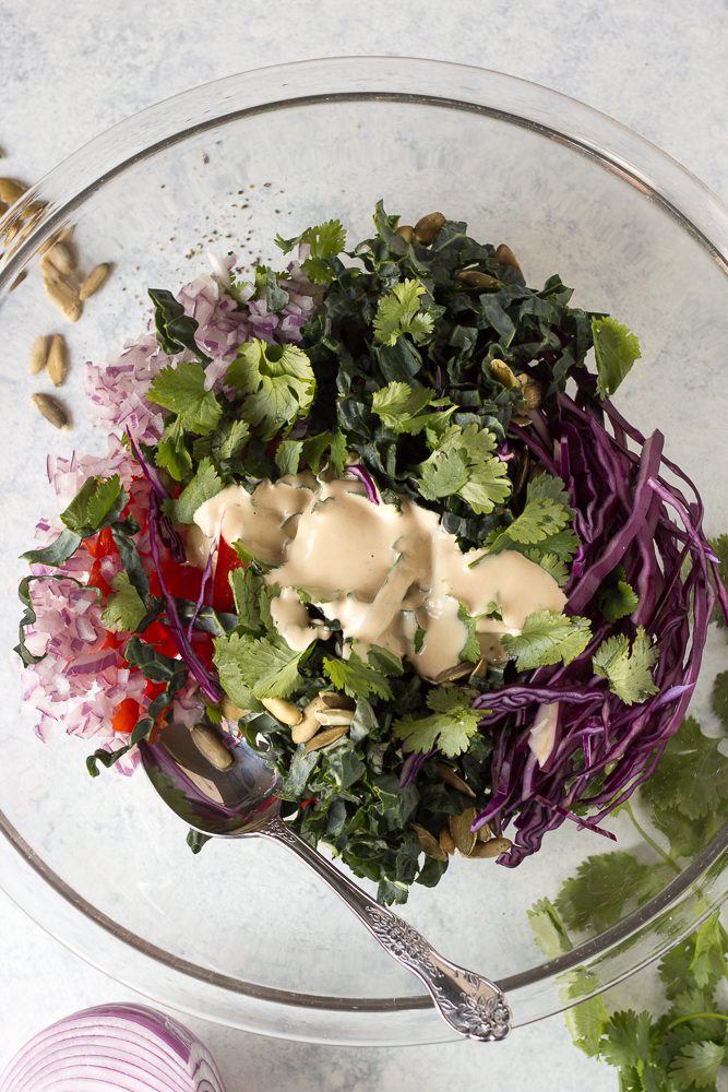 Thai Salad ingredients in a bowl with SunButter dressing poured on top by Flora & Vino