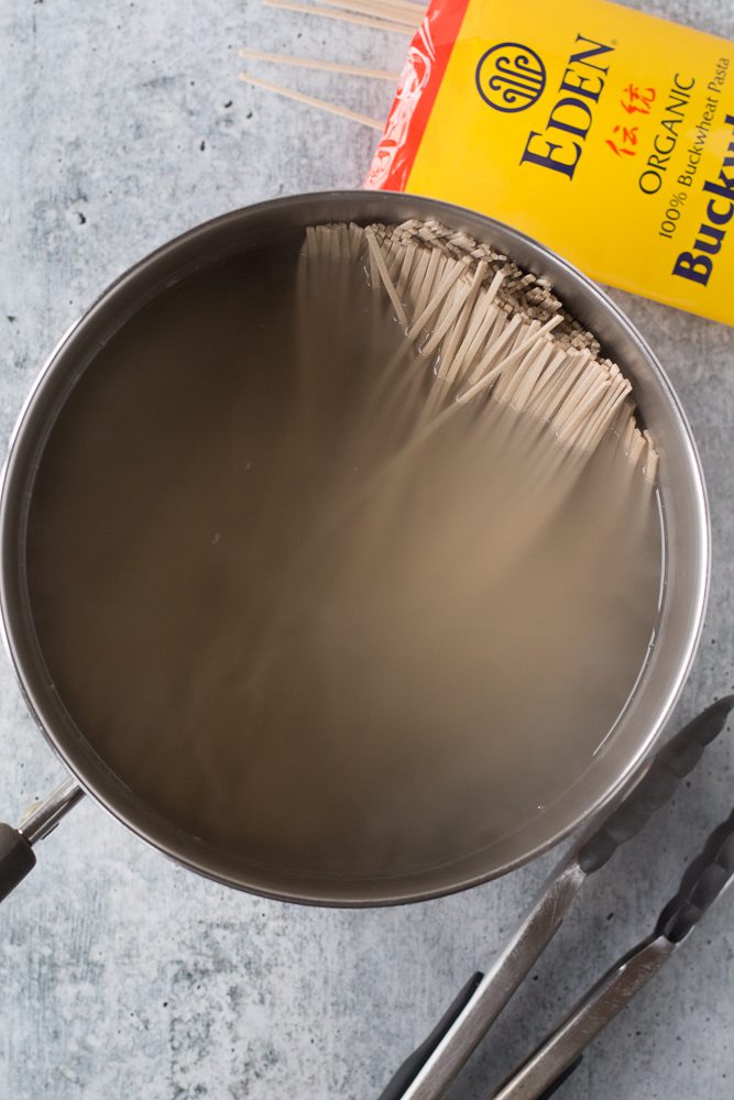 soba noodles cooking in hot water by Flora & Vino