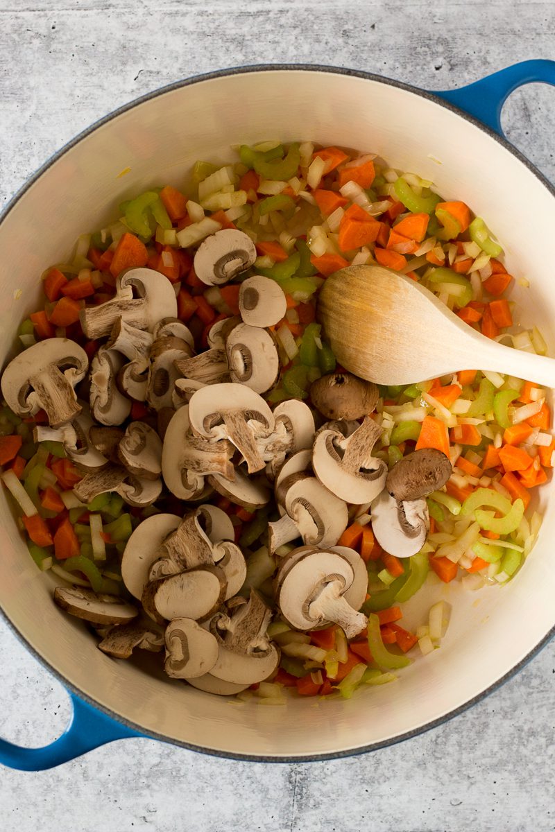 vegetables in stock pot with wooden spoon by Flora & Vino