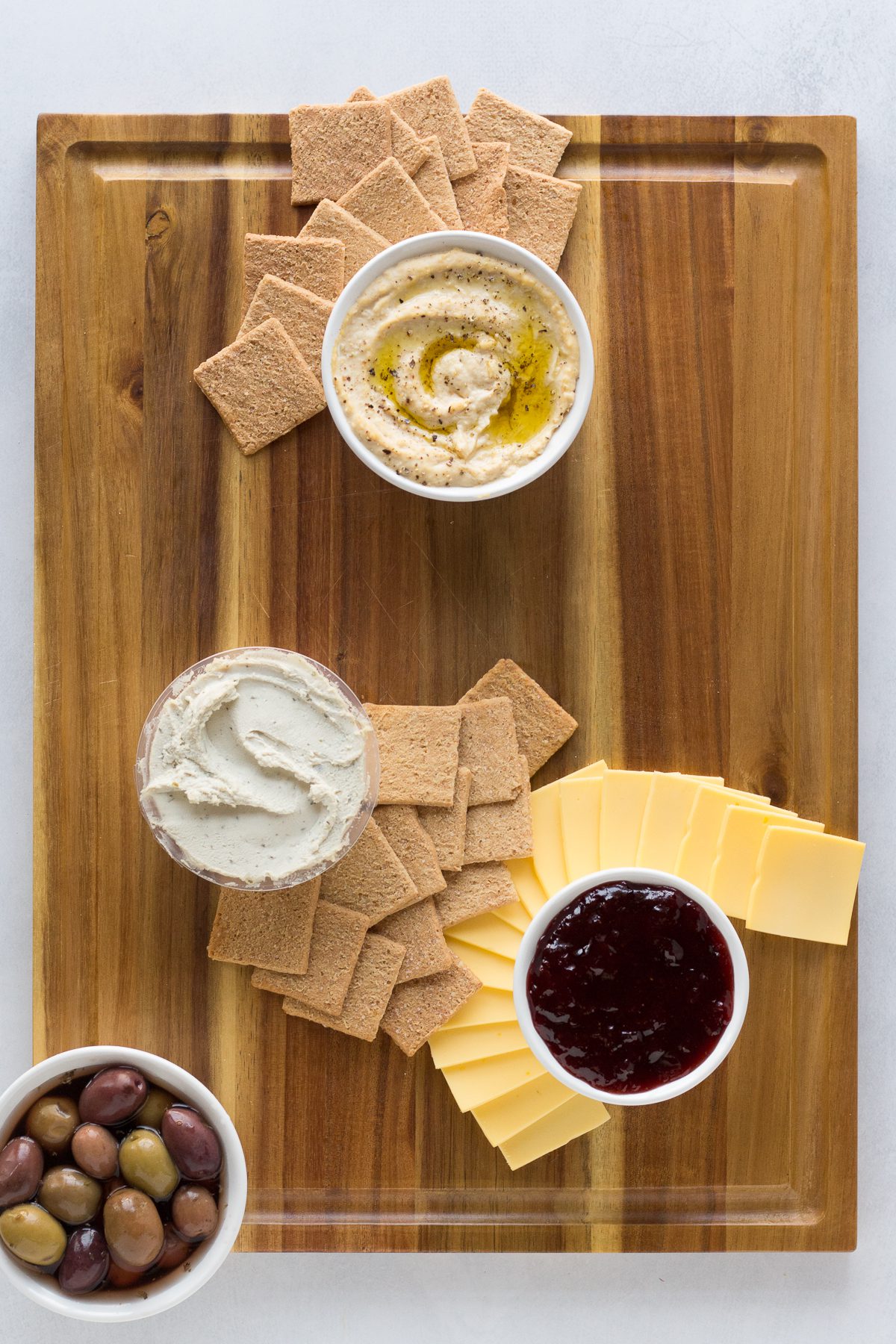 Vegan Cheese Board with crackers, cheese, jams, and olives by Flora & Vino