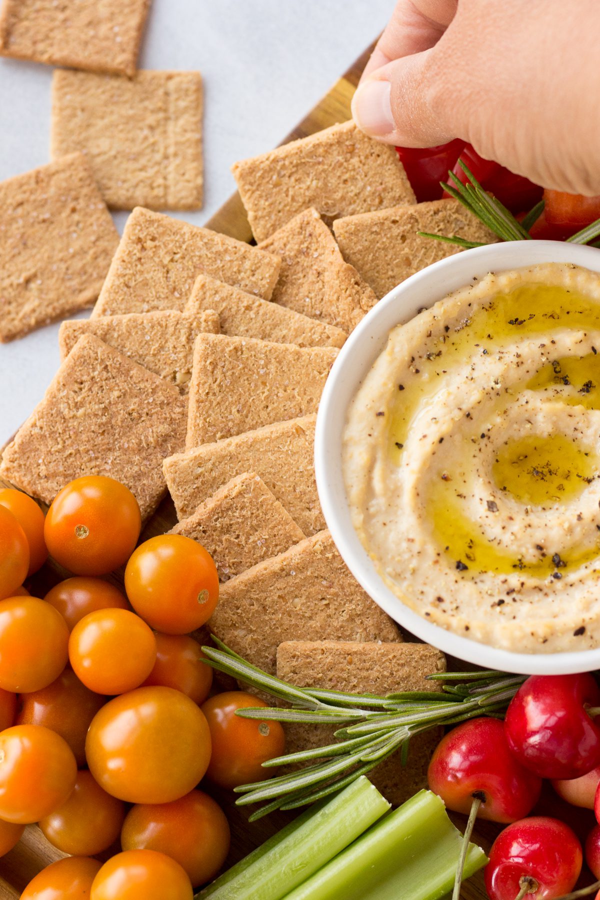 hand grabbing crackers from vegan cheese board by Flora & Vino