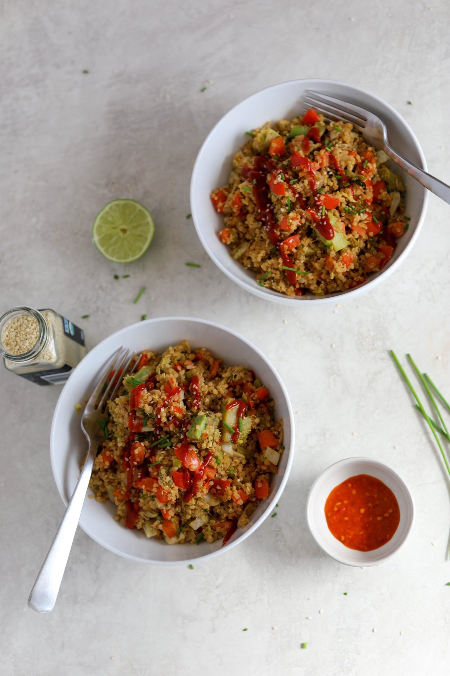 SunButter Quinoa Fried Rice served in bowls with sriracha and chives with sesame seeds and lime by Flora & Vino