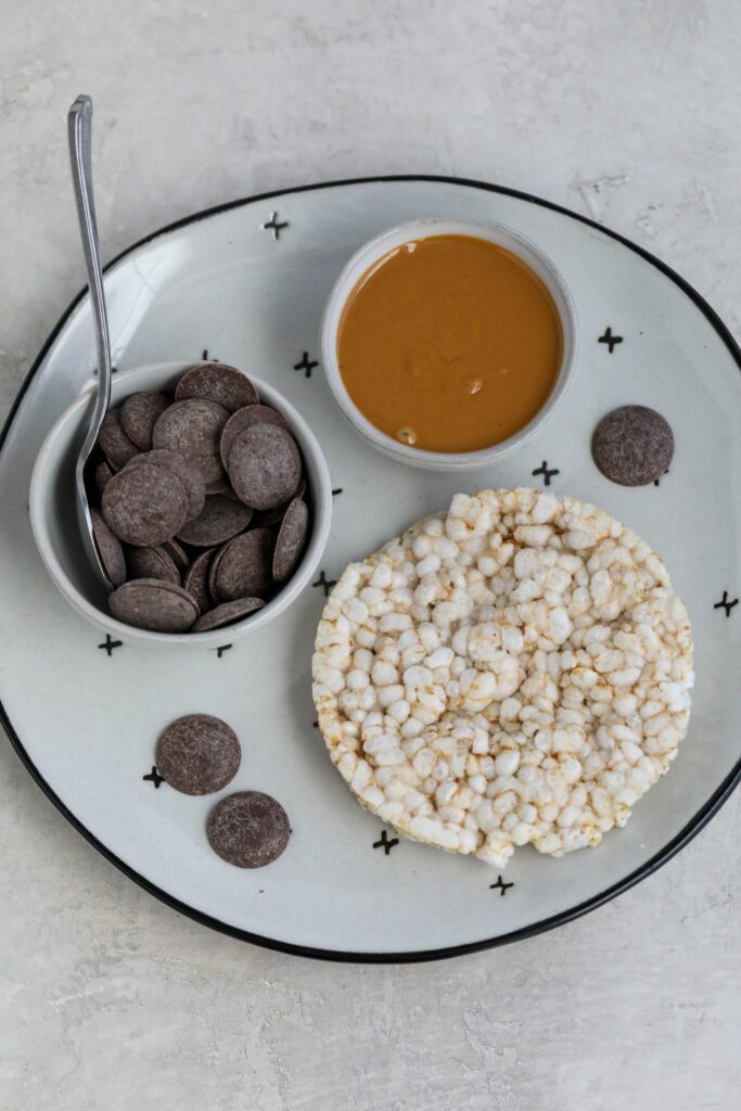 peanut butter, cacao wafers, and rice cake on plate