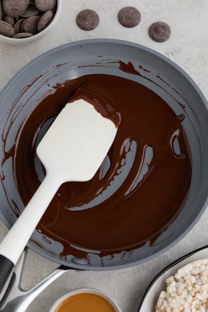 cacao wafers melted in green pan with spatula