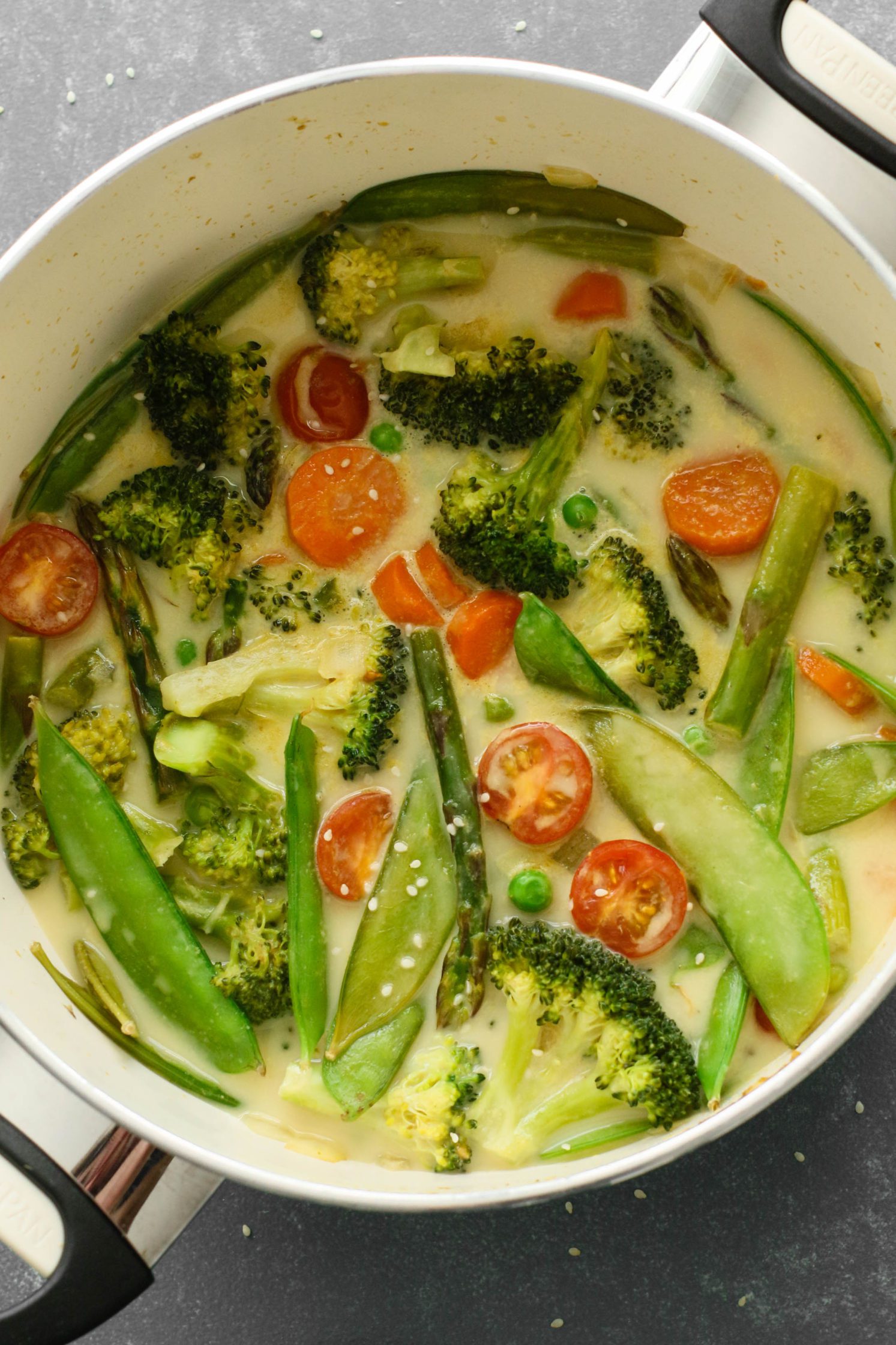 Green Coconut Curry in pot with sesame seeds on top 