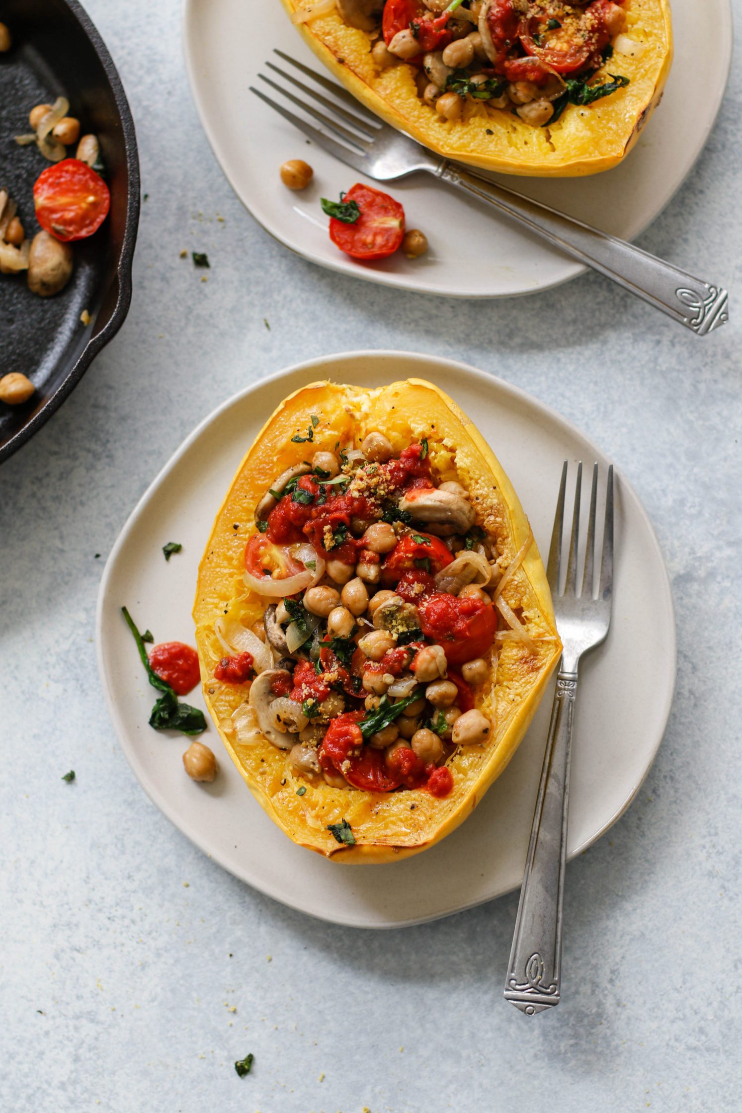 Italian Stuffed Spaghetti Squash served on plates with Crispy Chickpeas and fork by Flora & Vino