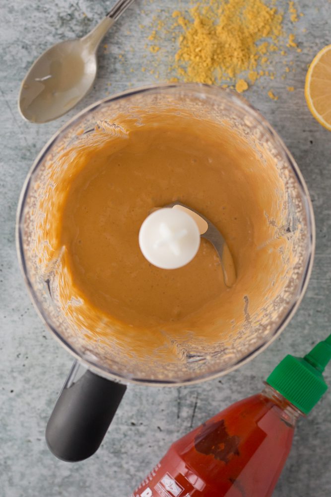 Spicy Tahini Dressing in blender with spoon by Flora & Vino