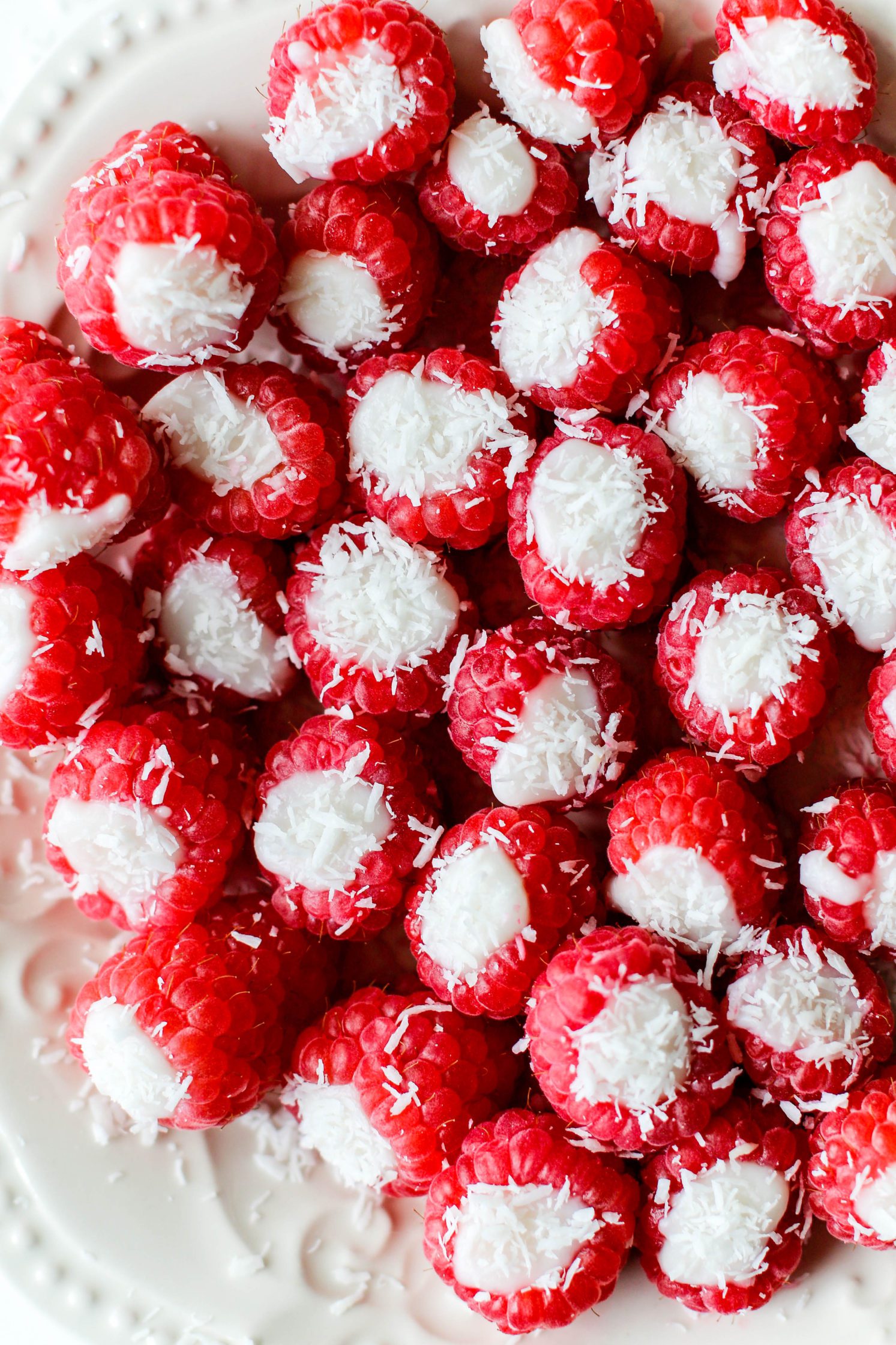 Coconut Stuffed Raspberries served on white plate topped with shredded coconut 