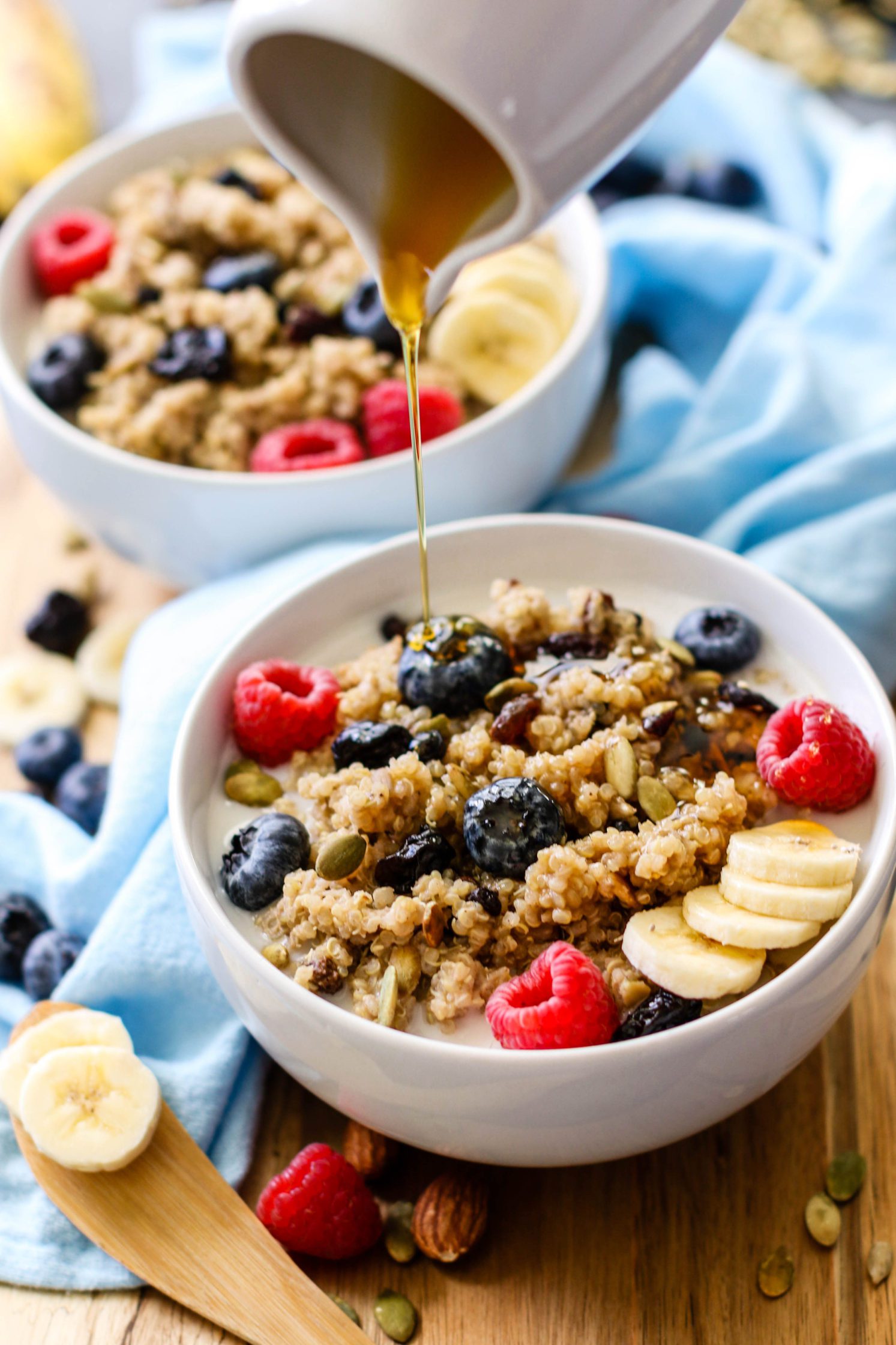pouring maple syrup on leftover quinoa breakfast bowls