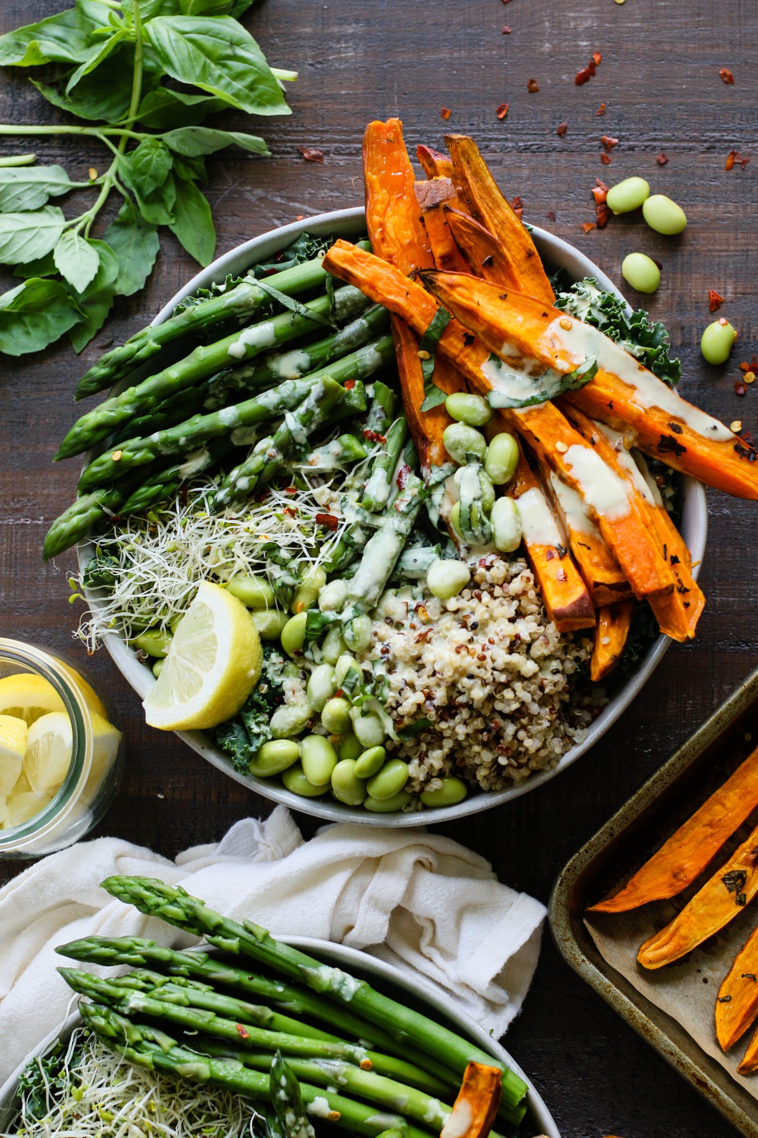 Sweet Potato Basil Quinoa Bowls served in a bowl and drizzled with Lemon Tahini with sweet potato fries on the side by Flora & Vino