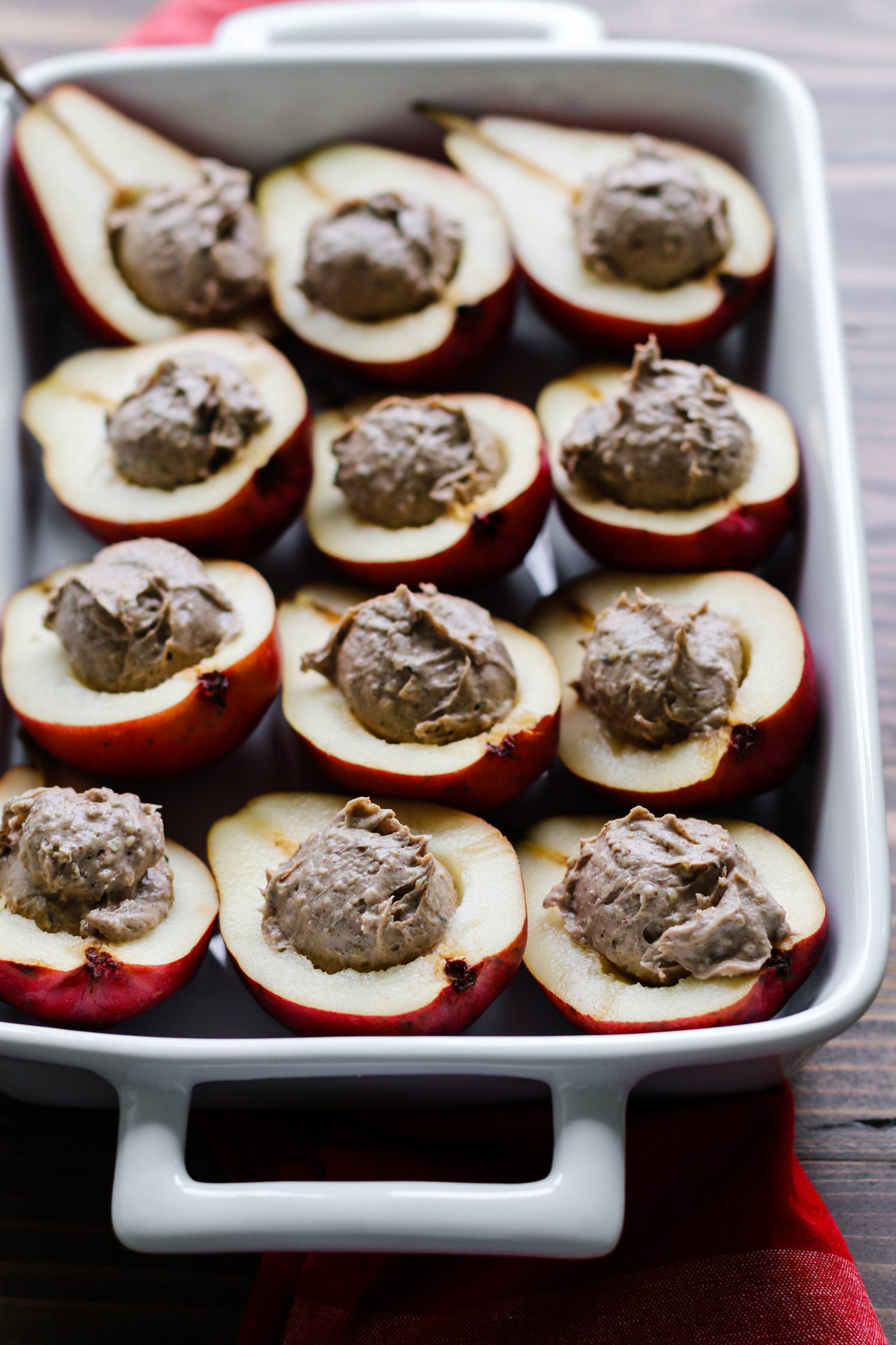 pears halved stuffed with protein nut butter in baking dish by Flora & Vino 