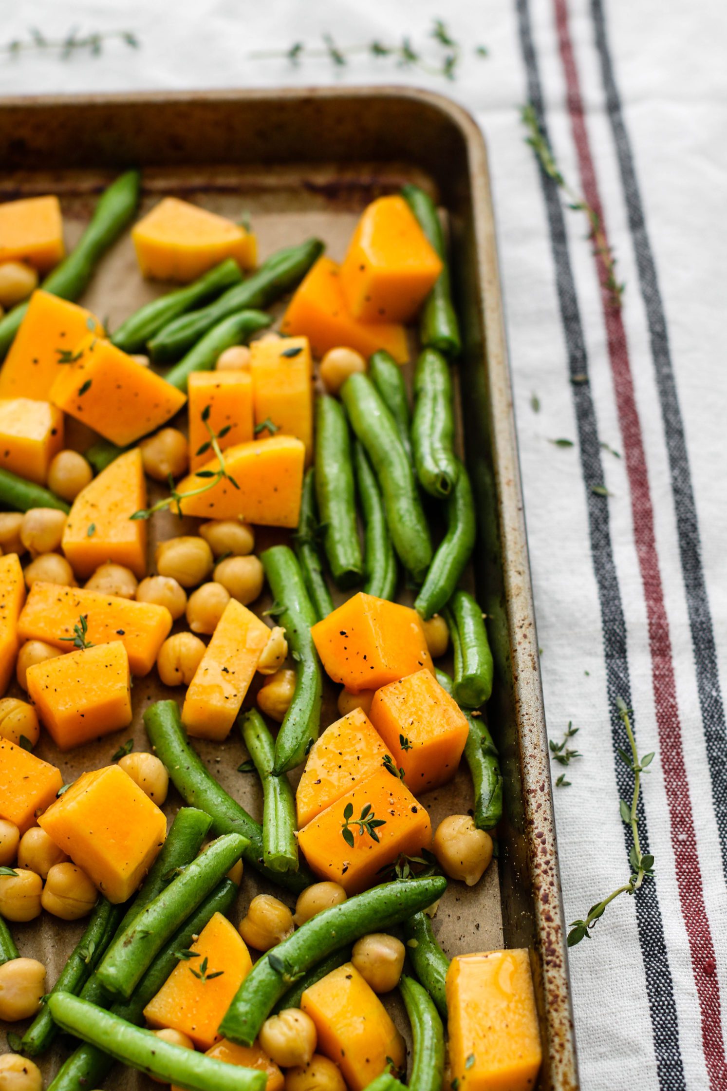 green beans, butternut squash, and chickpeas on a parchment lined baking sheet by Flora & Vino