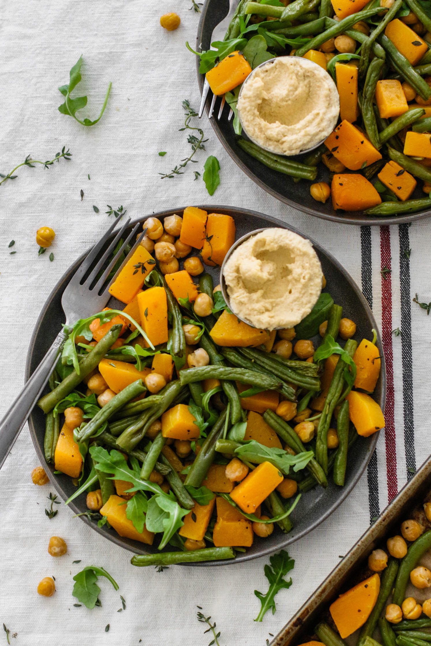 Butternut Squash & Chickpea Bake served on plates with a fork by Flora & Vino