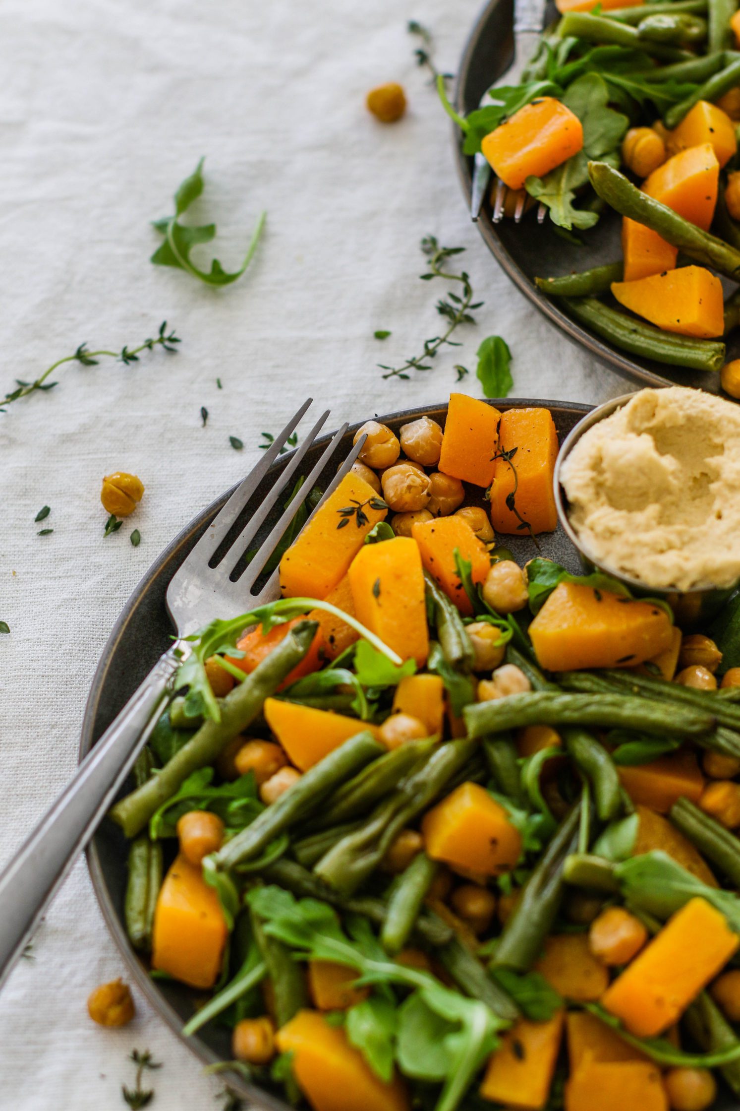 Butternut Squash & Chickpea Bake served on plates with a fork by Flora & Vino