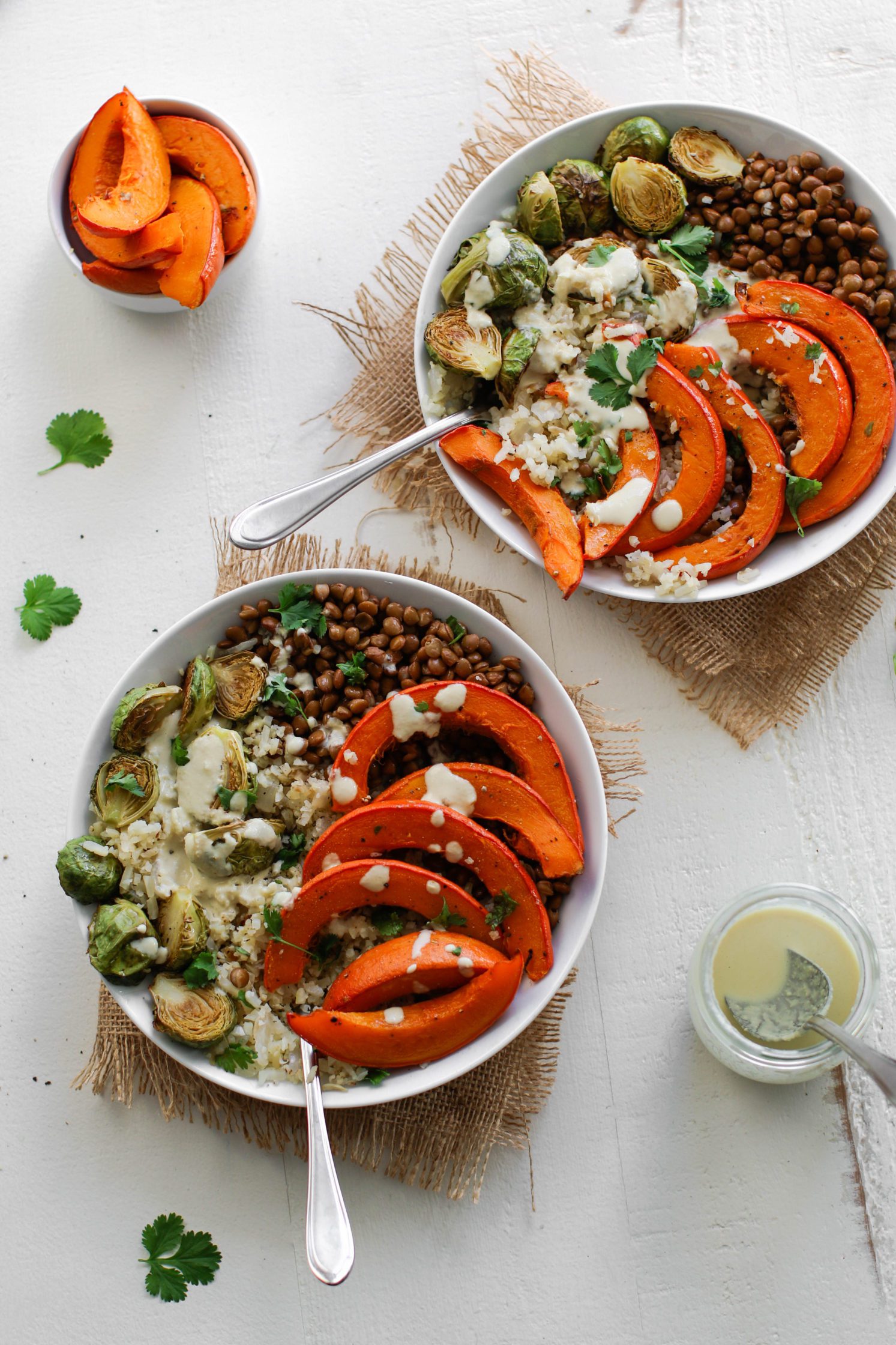 Lentil & Winter Squash Cauliflower Rice Power Bowl served in bowls topped with tahini dressing with spoons