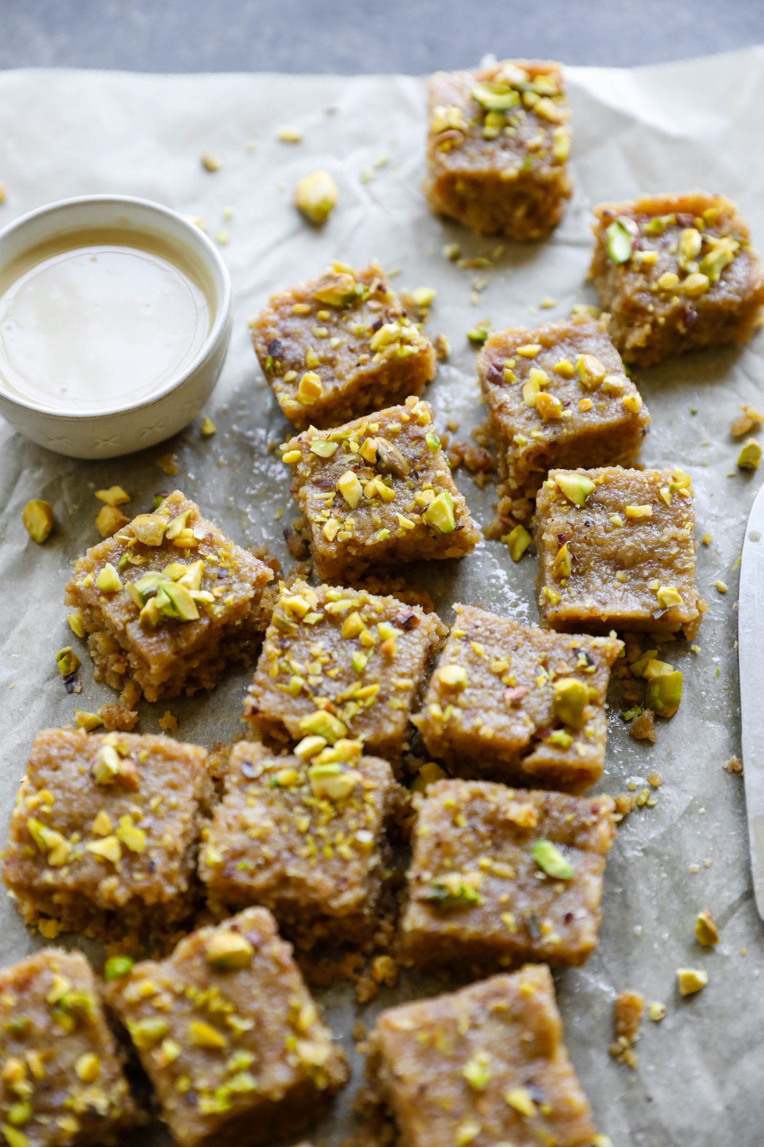 Vegan Tahini Date Halva sliced on parchment paper with tahini by Flora & Vino