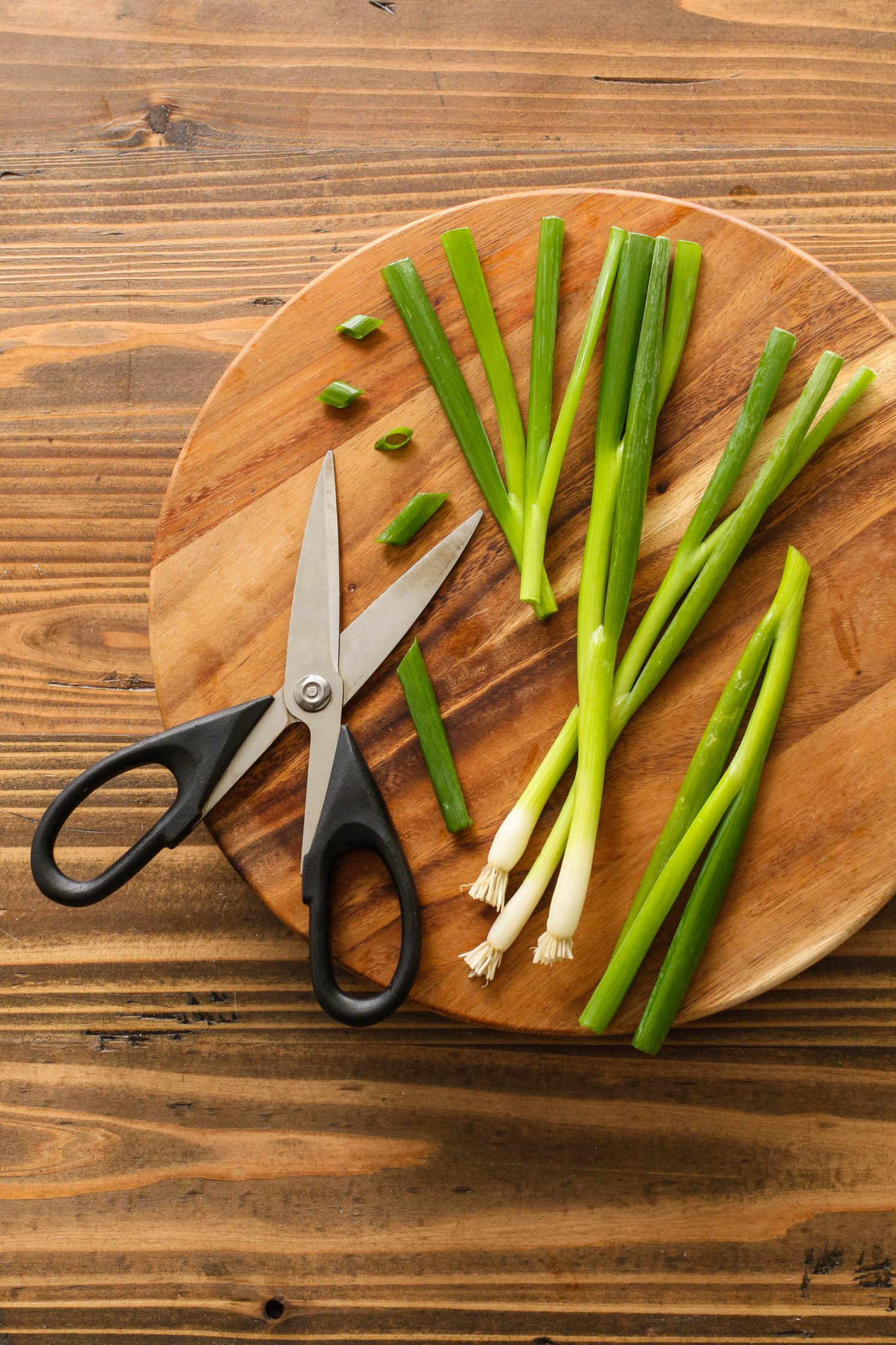green onion cut with scissors on cutting board
