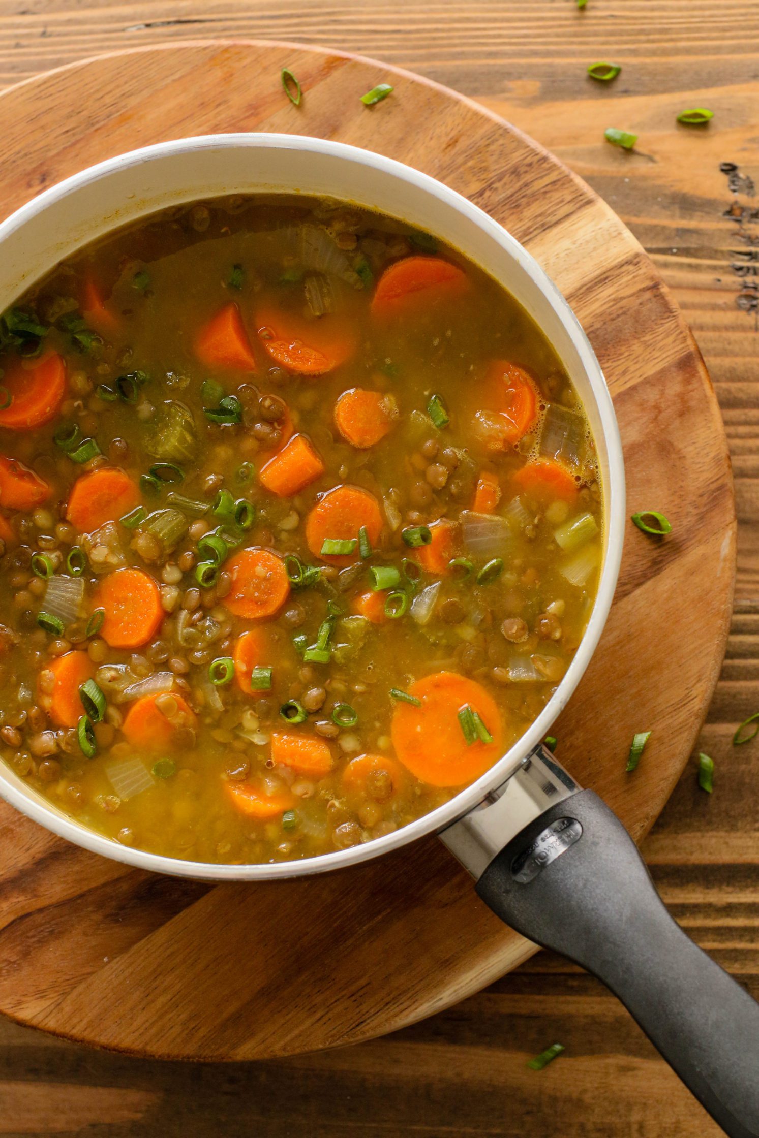 Everyday Carrot Lentil Soup cooking in pot with green onion