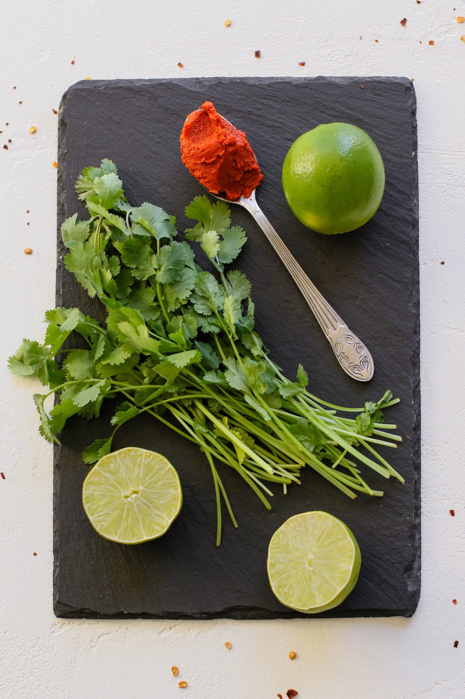 lime, curry paste, and cilantro on serving board by Flora & vino