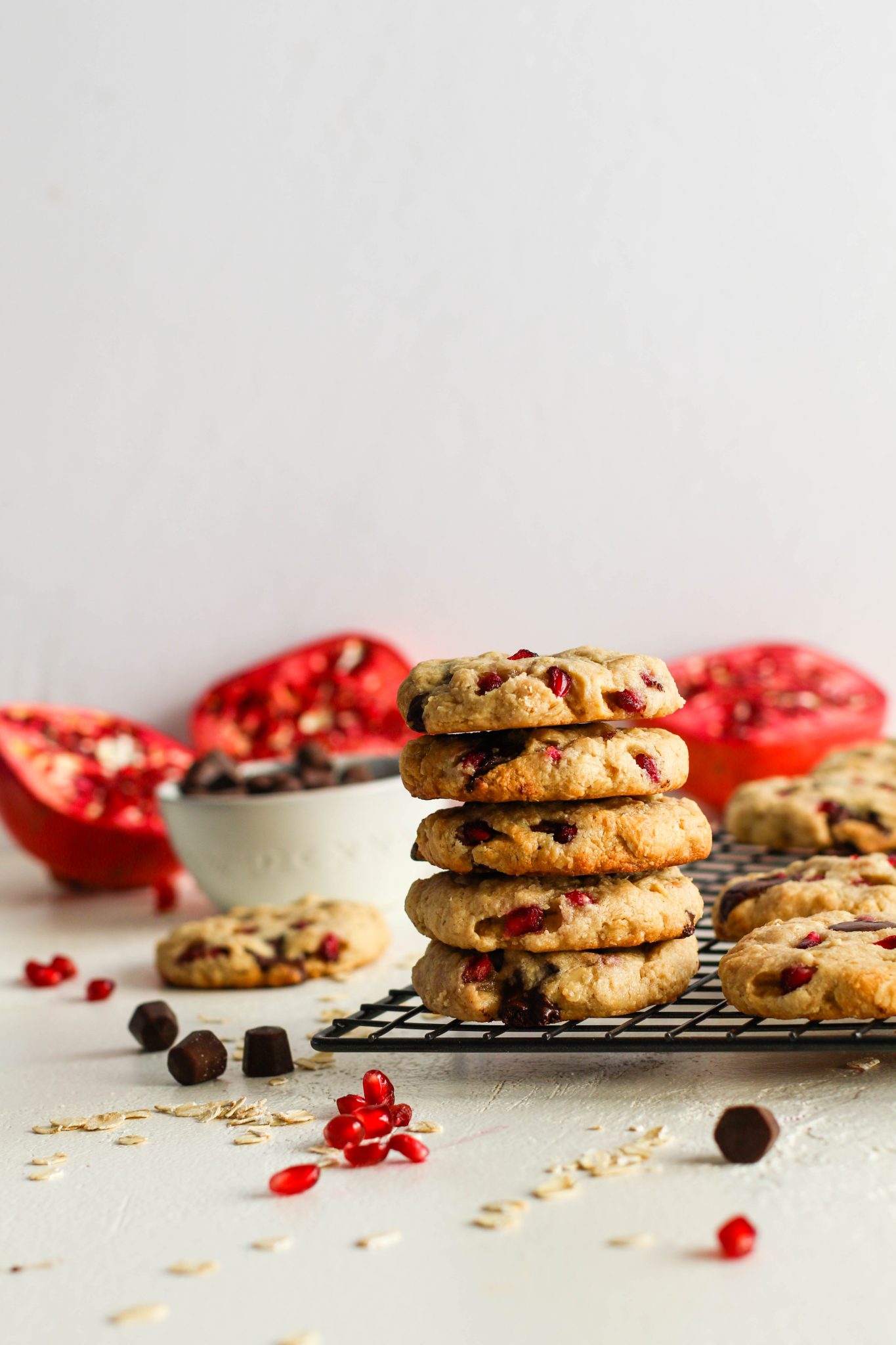 Pomegranate Oatmeal Chocolate Chip Cookies stacked on cooling rack by Flora & Vino 