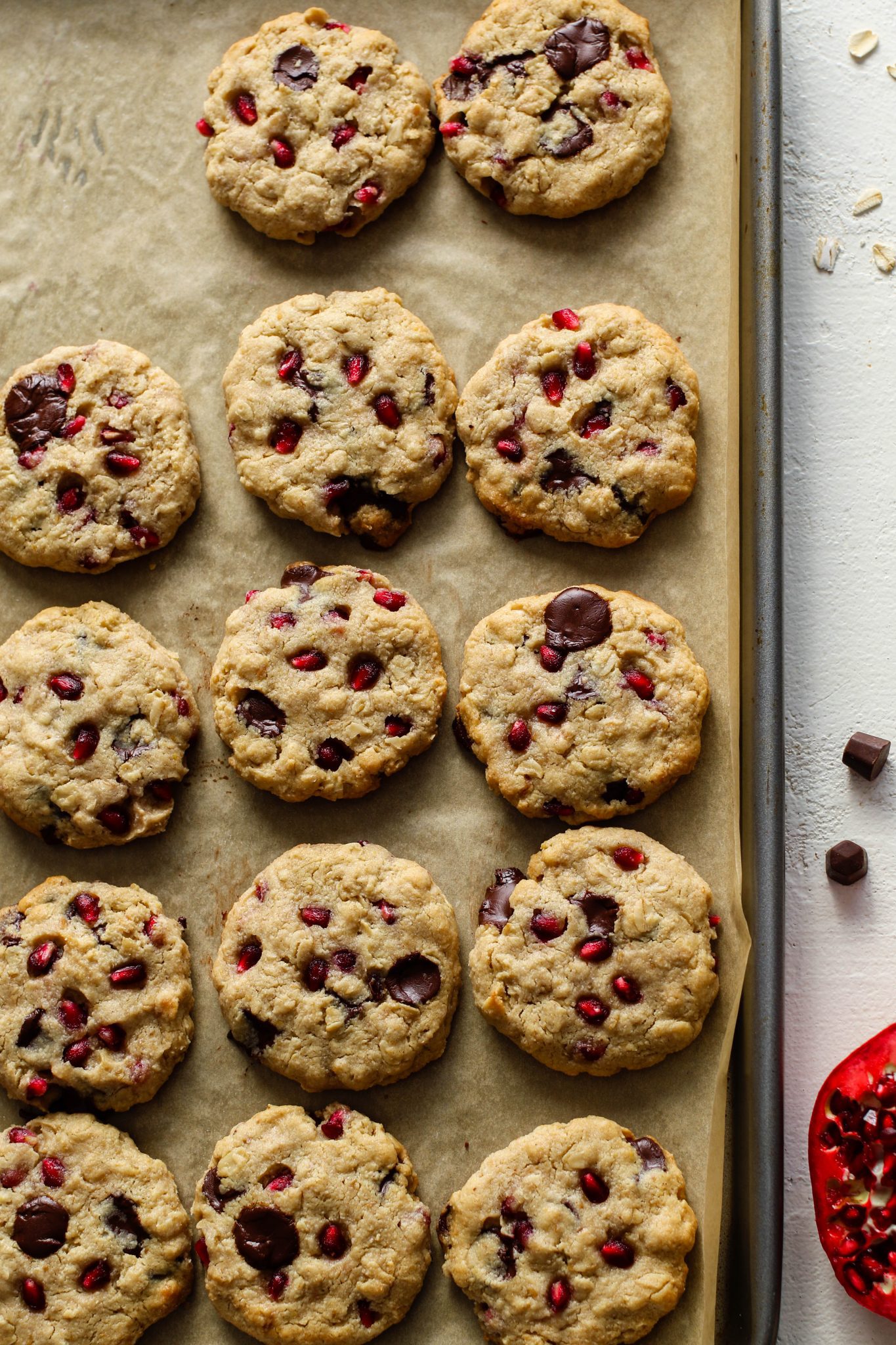 Pomegranate Oatmeal Chocolate Chip Cookies on parchment lined baking sheet by Flora & Vino