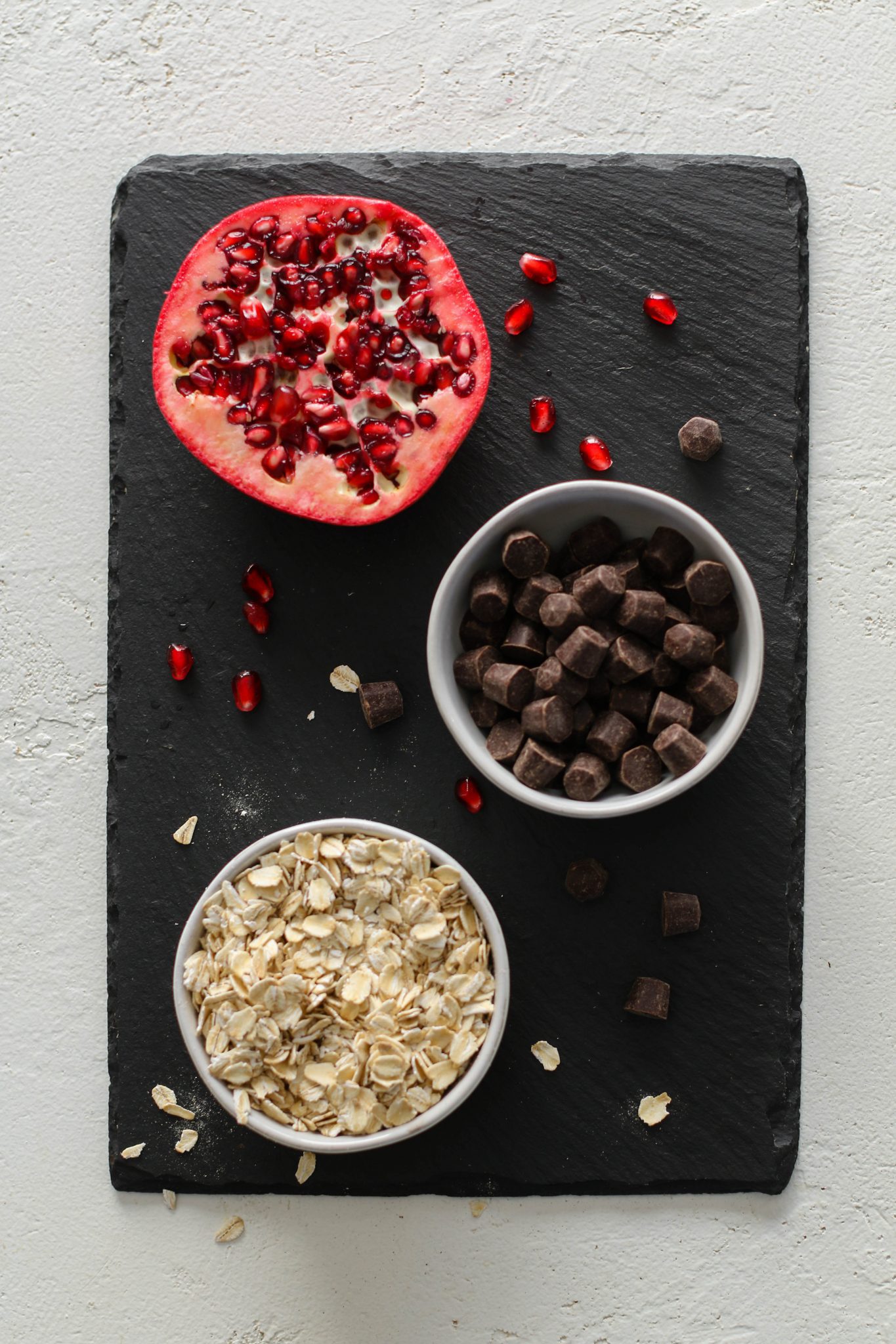 pomegranate, chocolate chips, and oatmeal on serving board by Flora & Vino 