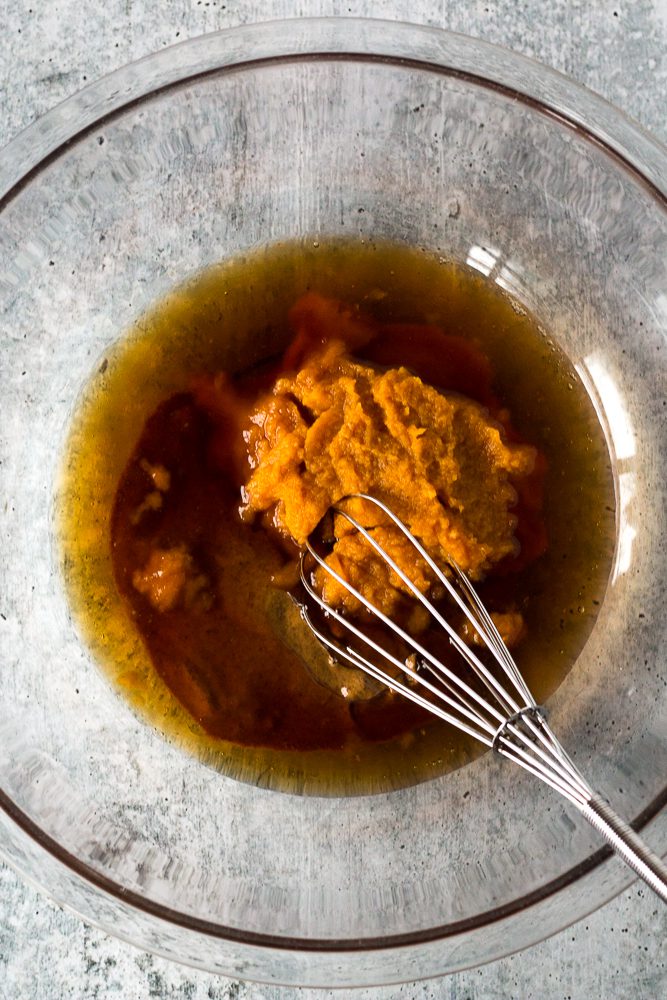 wet ingredients for pumpkin brownies in glass bowl