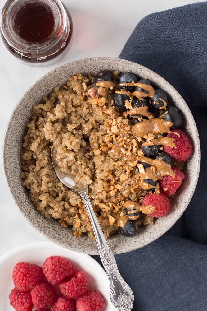 Coconut Quinoa Porridge served in bowls with berries and nut butter by Flora & Vino