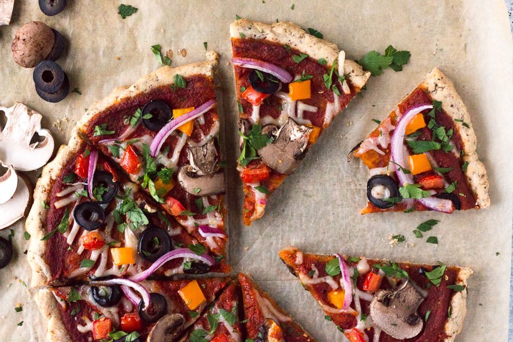 Veggie Lover's Flatbread Pizza cut in slices and served on parchment paper sprinkled with herbs 