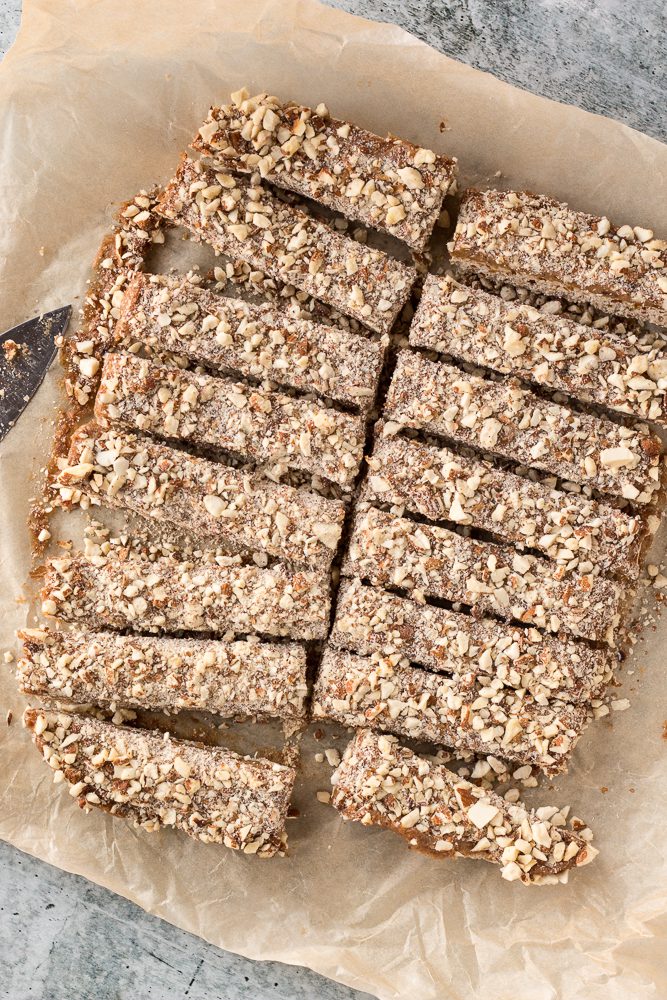 Date Caramel Nougat Bars sliced on parchment paper by Flora & Vino